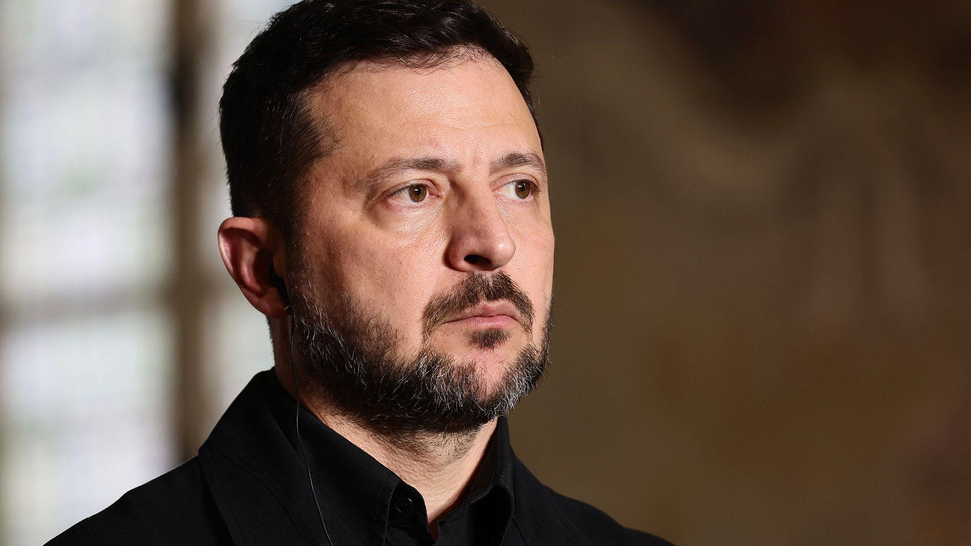 Head and shoulders crop of Zelensky looking away from camera while wearing a black shirt against a neutral background, as he addresses a press conference after the summit of the Coalition of the Willing to support Ukraine at the Hotel des Invalides in Paris on 13 July.
