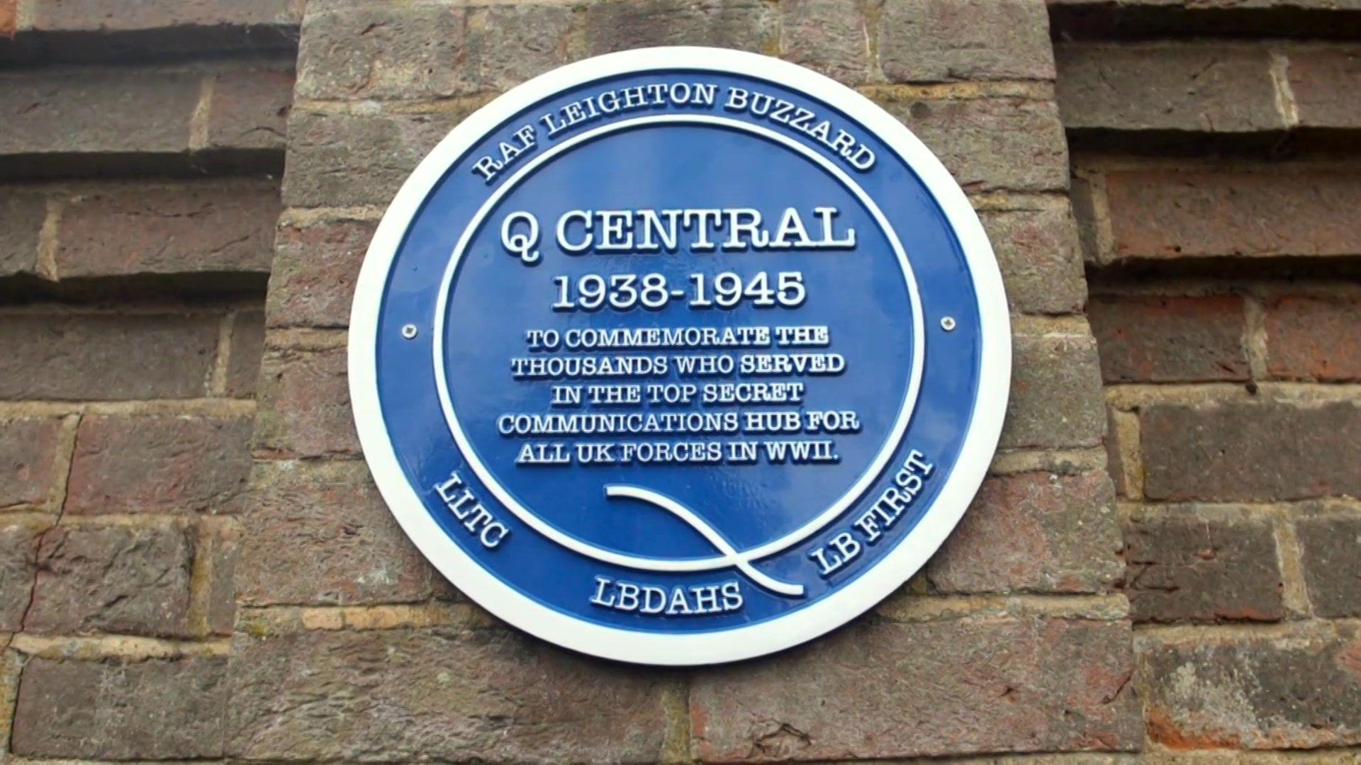 A blue plaque making the work of Q Central on the side of the building