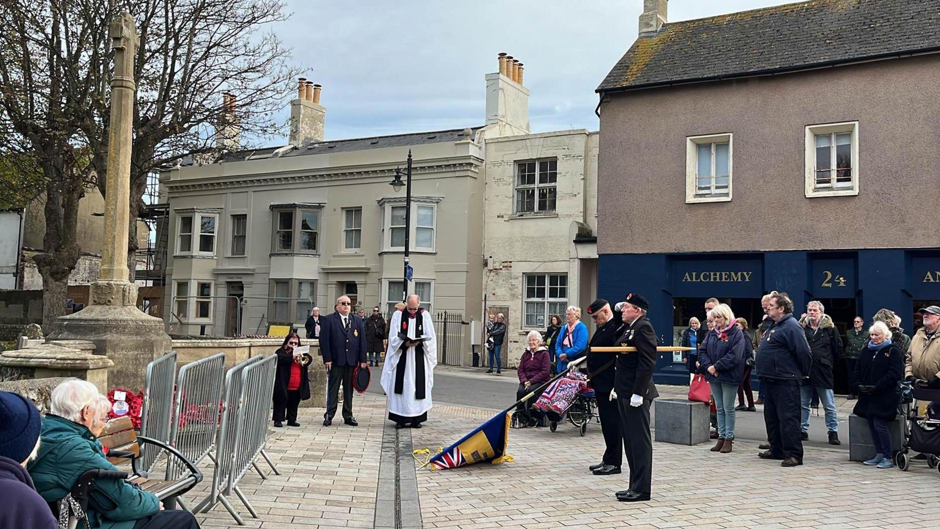 Veterans and members of the public gathering before Shoreham-by-Sea's war memorial for an Armistice Day event.