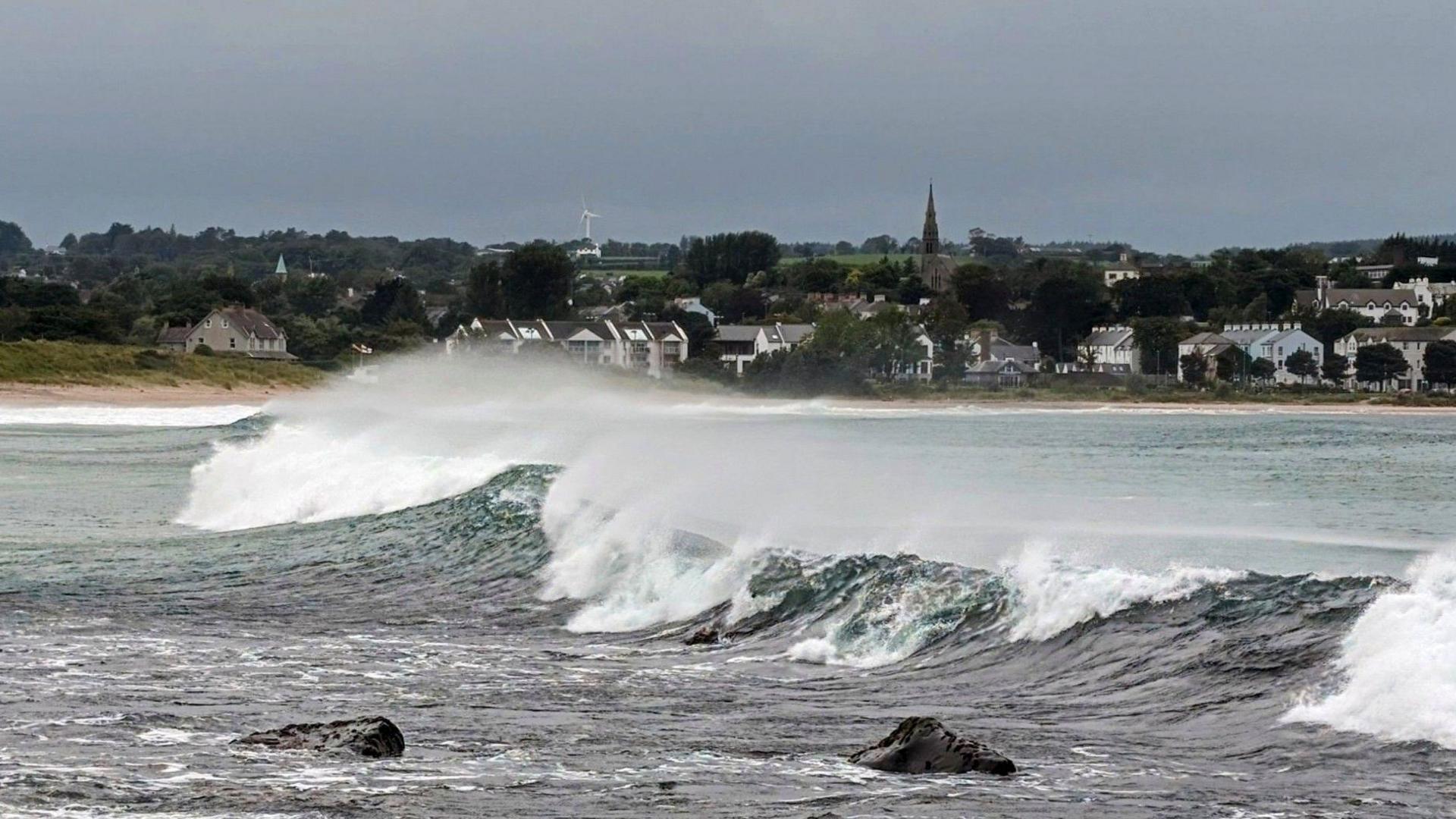 A wave on Ballycastle beach. The sky is grey.