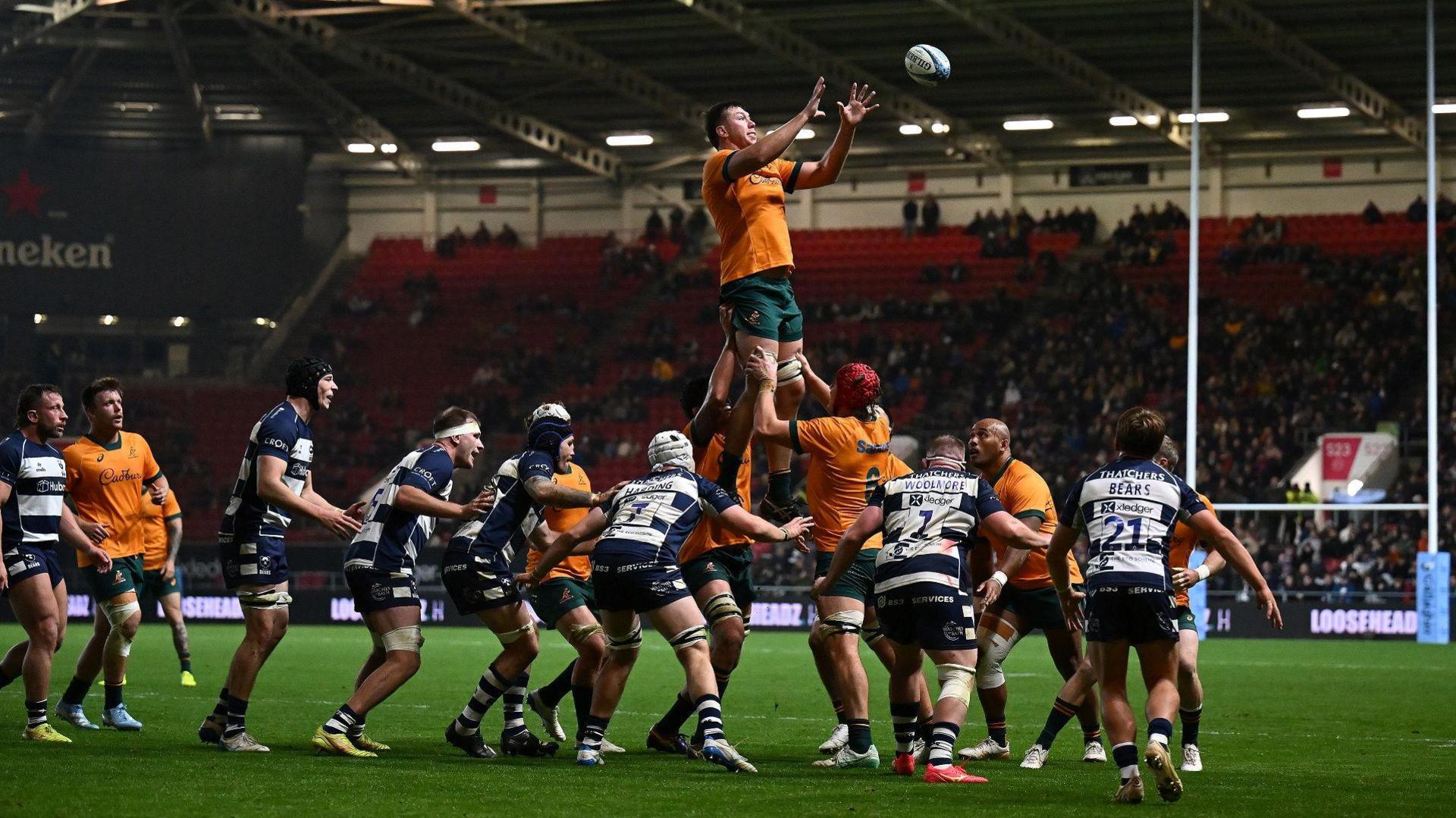 Players from Australia and Bristol contest a lineout during a match at Ashton Gate. An Australian player is about to catch the ball as he is being lifted by his team-mates.