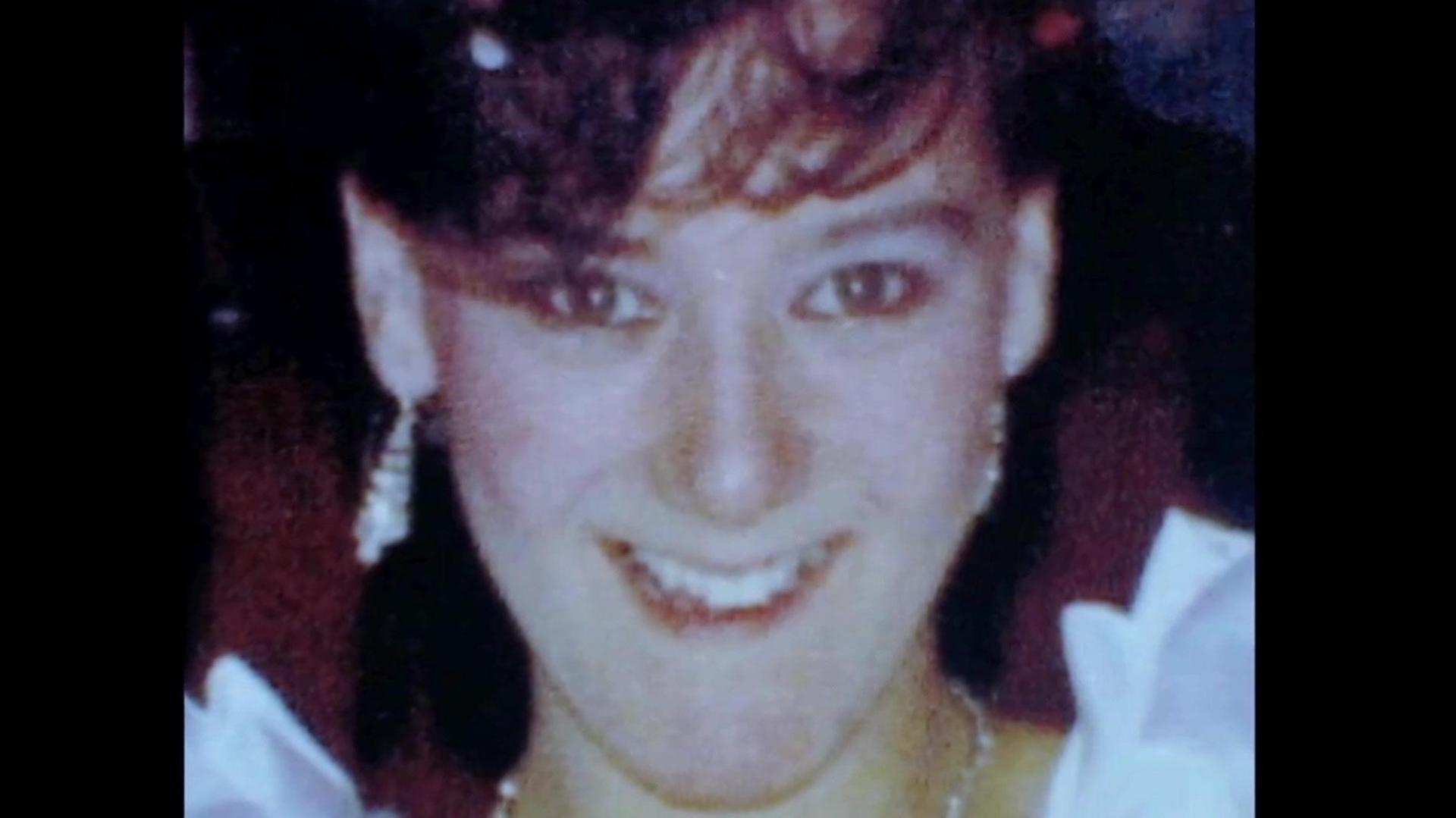 Julie Hogg, a young woman with brown hair smiles at the camera.