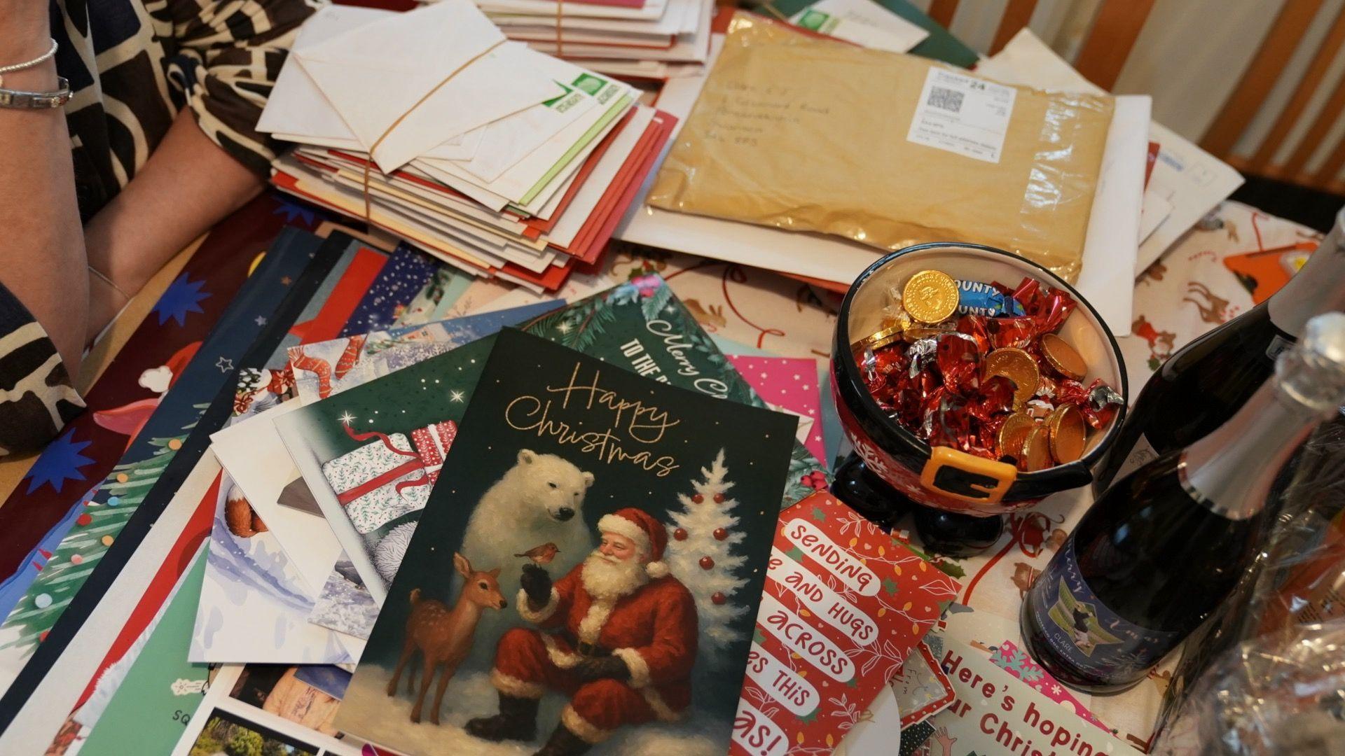 Pentwr o gardiau ac anrhegion ar fwrdd