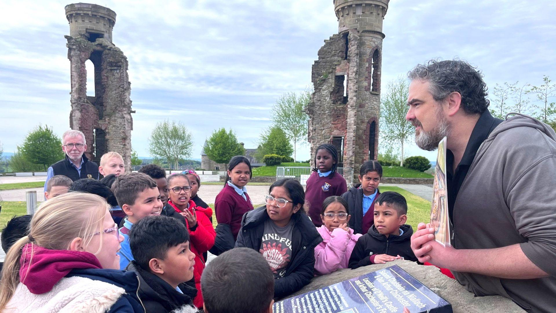 Archaeologist Brian Sloane on the site of the Hill of O'Neill with a group of schoolchildren