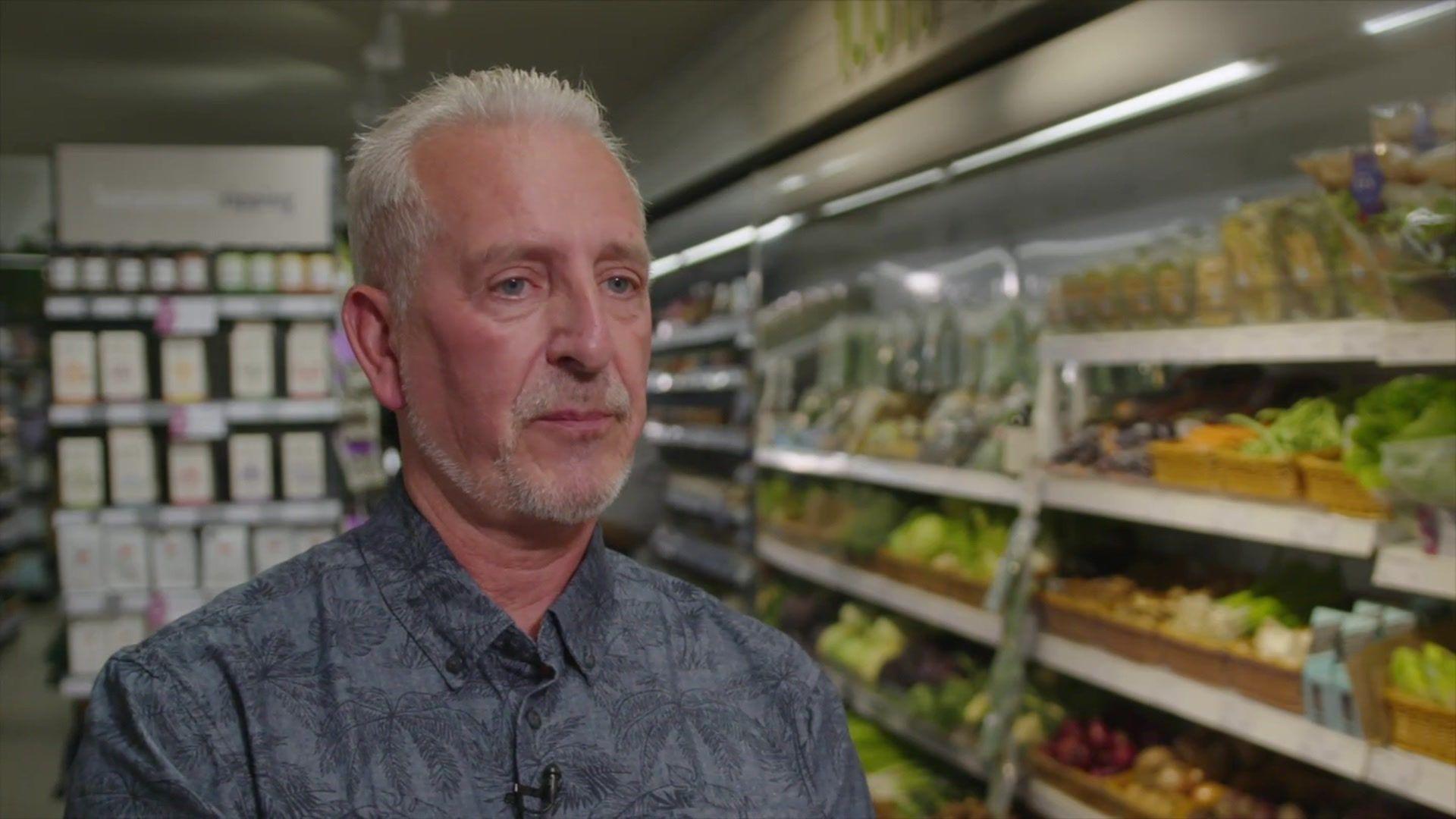 Richard Fowler in front of a fridge of fresh produce