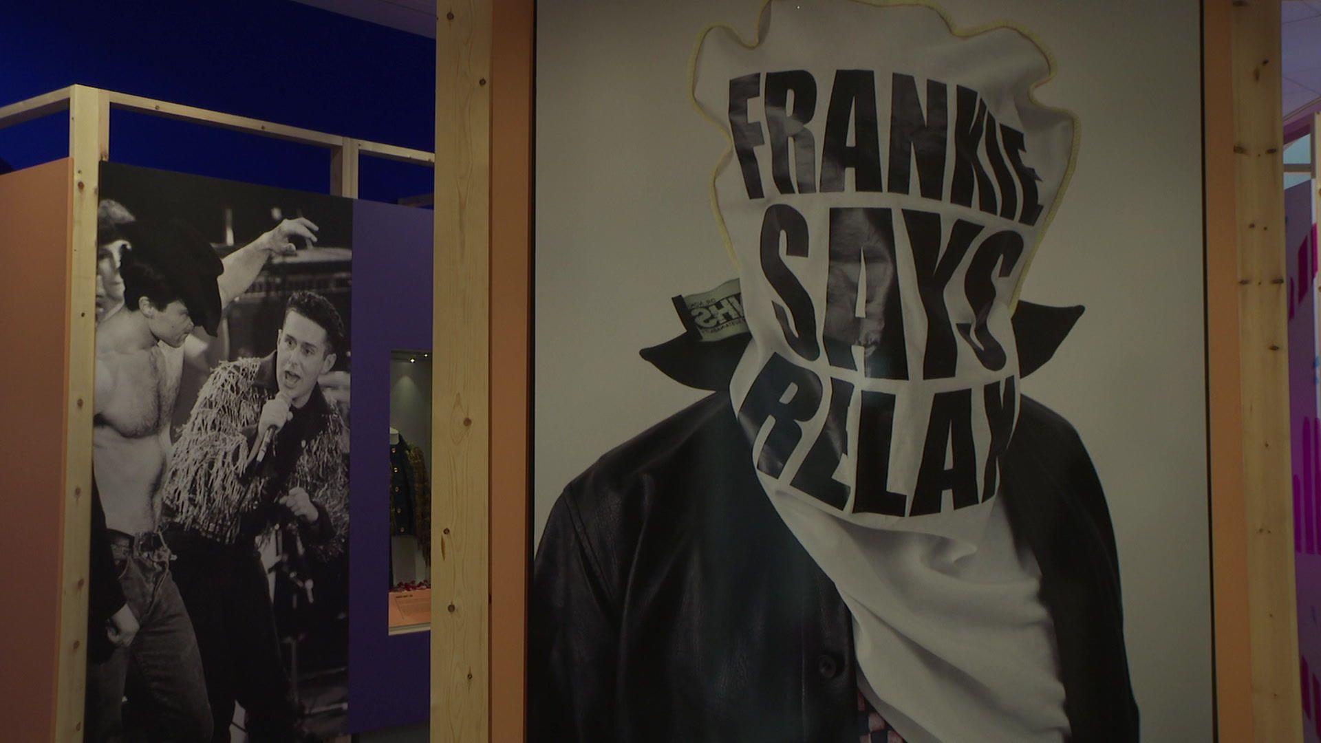 Painting of a man with a bag that says "Franke Says Relax" over his head. In the background, a picture of Holly Johnson singing while a shirtless man in a cowboy hat dances next to him.