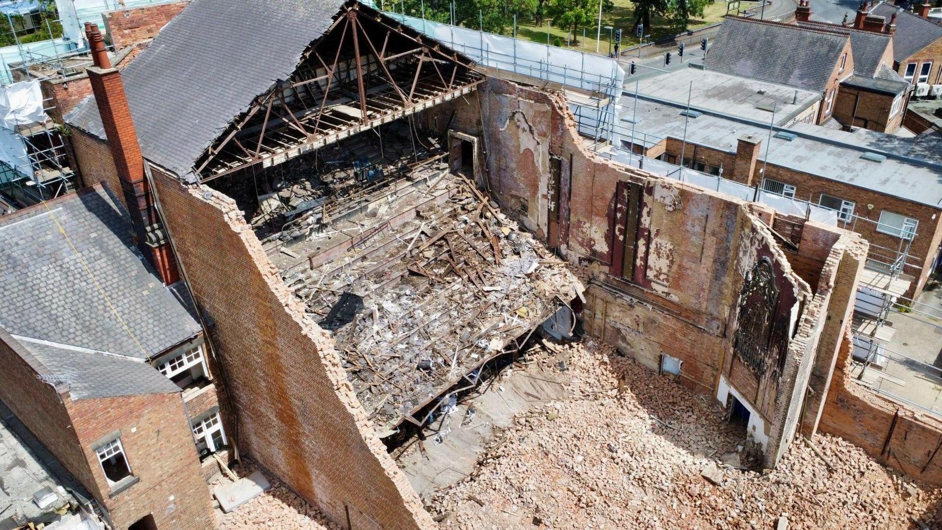 The remains of the building and brick rubble strewn nearby viewed from the air