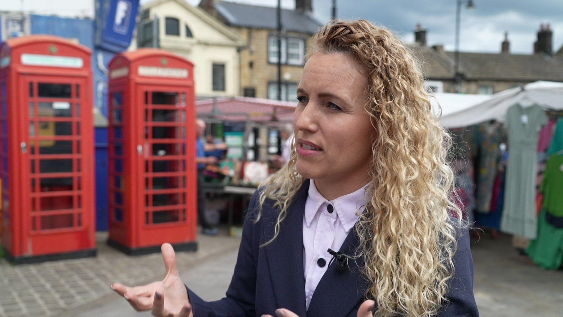 Katie White, MP for Leeds North West, with long blonde curly hair.