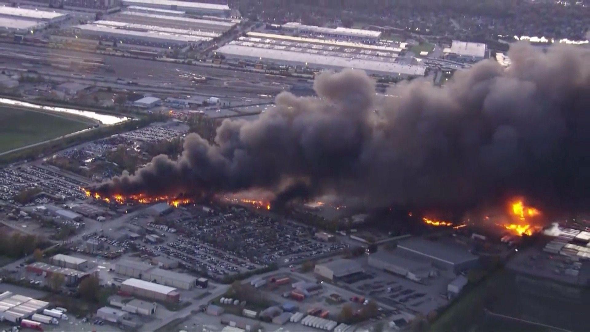 A long plume of smoke rises from Louisville, Kentucky over tens of buildings.