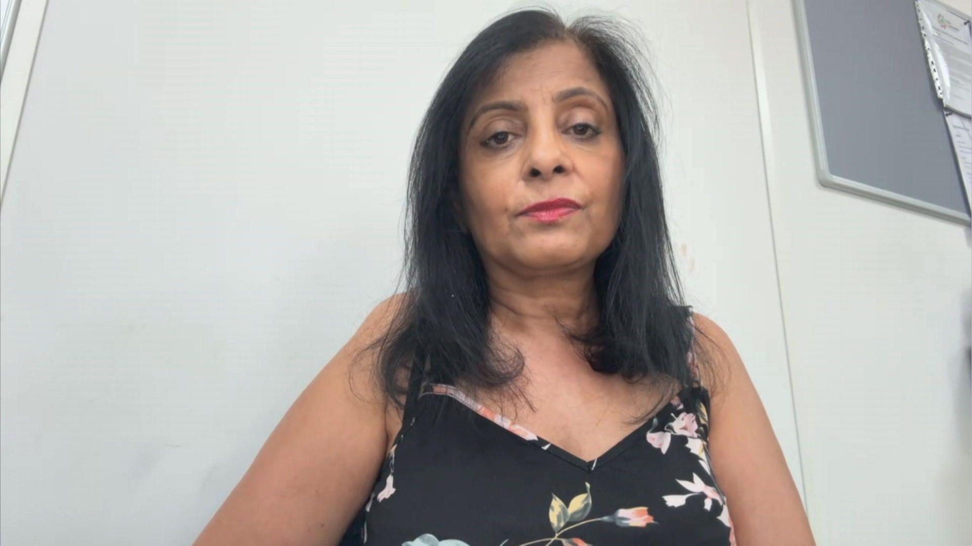 A woman with long black hair and black flowery dress.