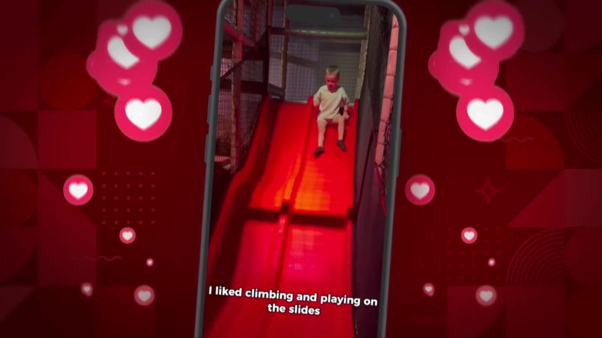 A boy going down a red slide