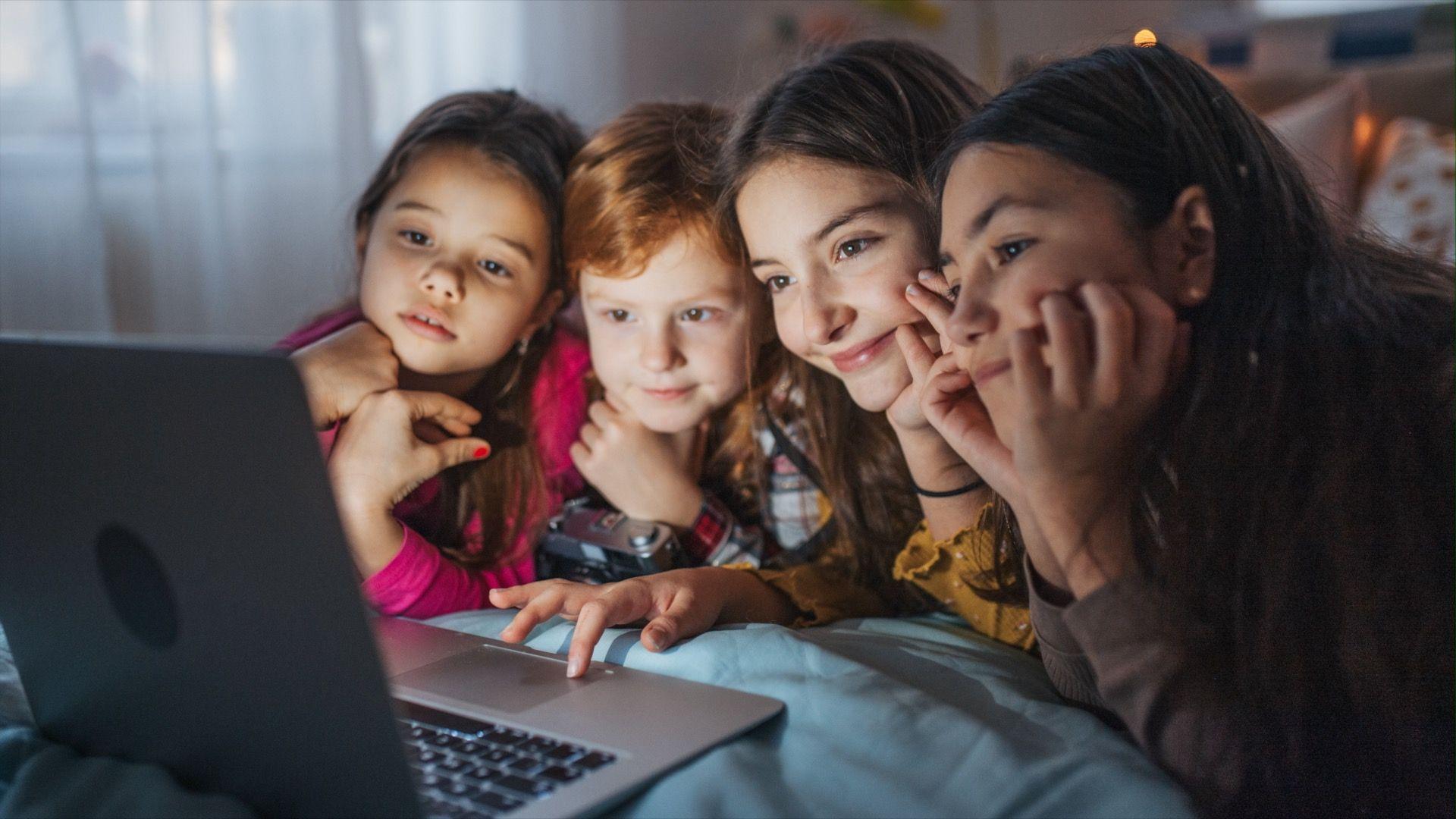 4 girls of different ages looking at a laptop computer