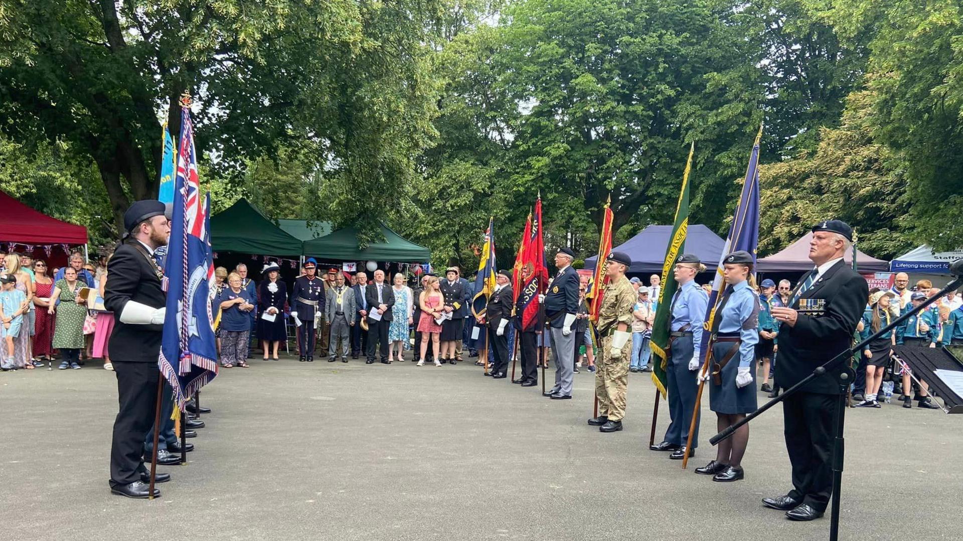 Armed forces organisations line up carrying ceremonial flags