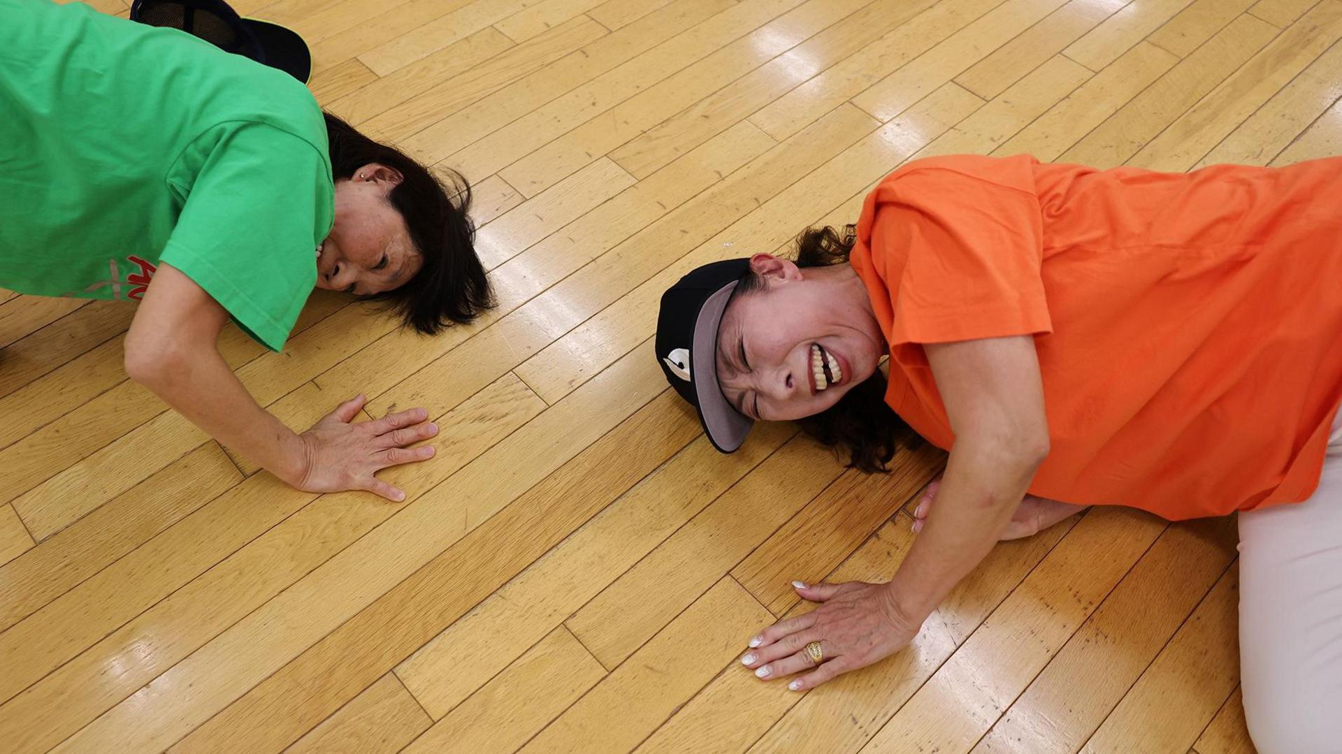 two elderly people, breakdancing and laughing