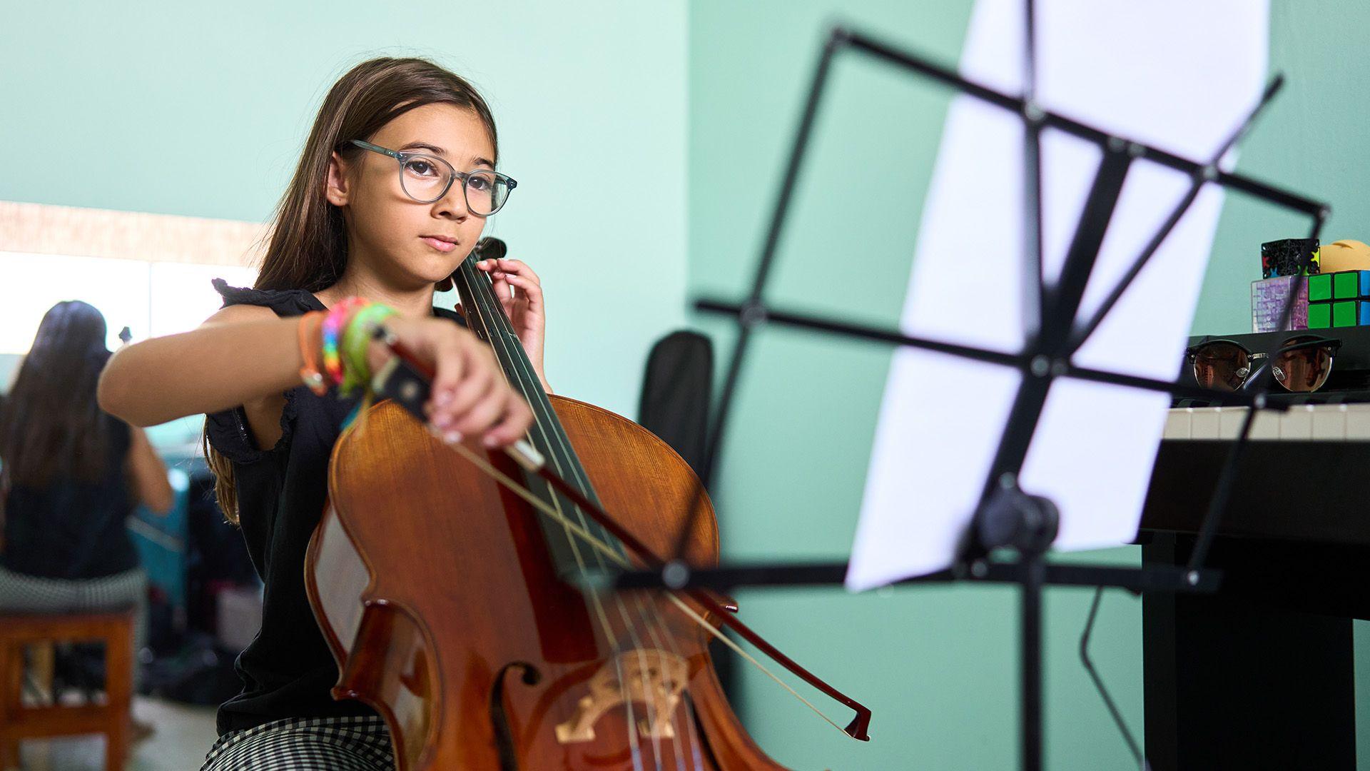 A girl sits and plays the cello