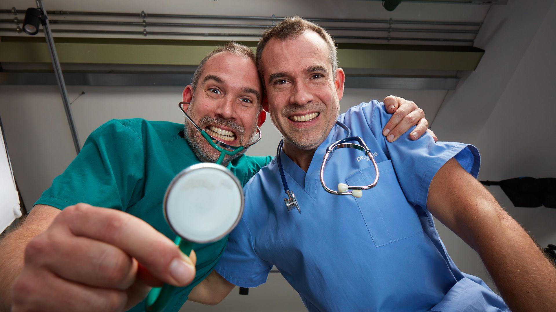 Dr Chris and Dr Xand can be seen smiling at the and holding up a piece of medical equipment - a stethoscope - towards the camera.