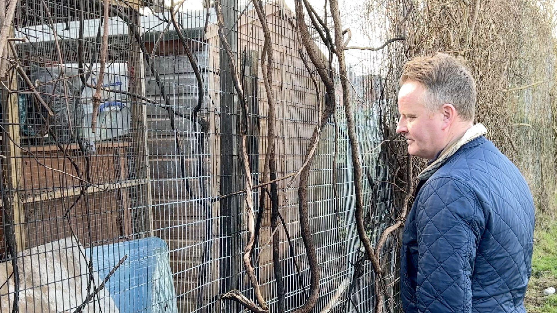 Peter Finnan who tried to save the animals caught in the fire, looks at the fire damage.