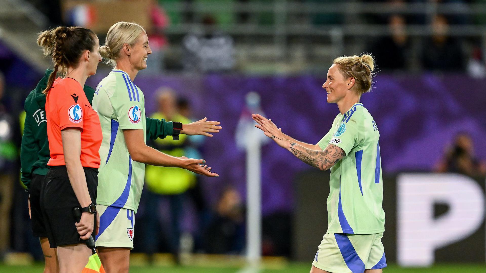 Sophie Ingle smiles and prepares to touch hands with a smiling Jess Fishlock as she replaces her during Wales' Euro 2025 defeat to France 