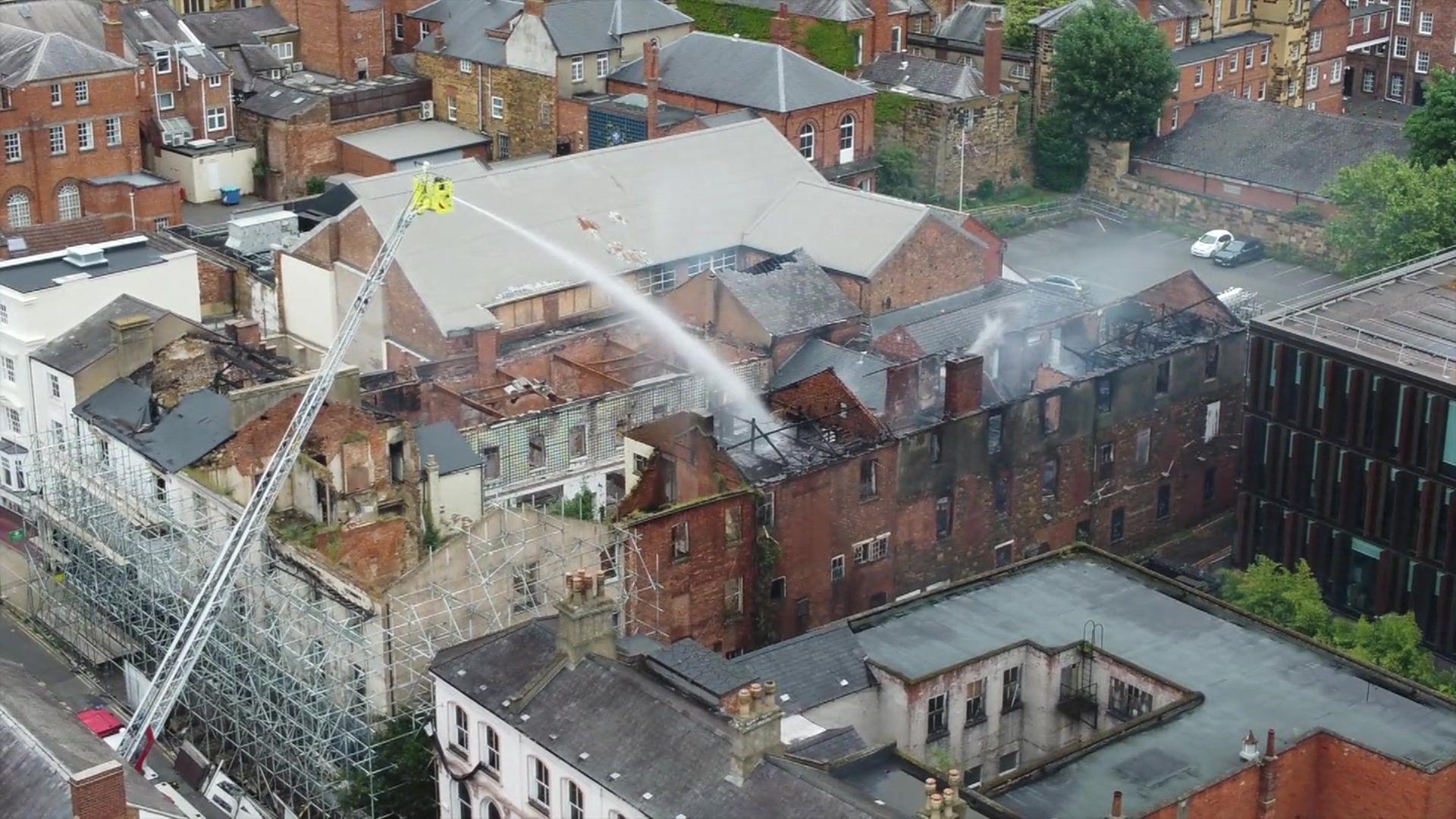 Firefighters on a ladder putting out a fire pictured from the air