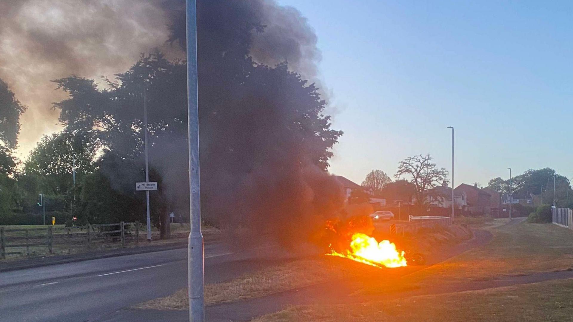 A motorcycle well alight on the side of a road