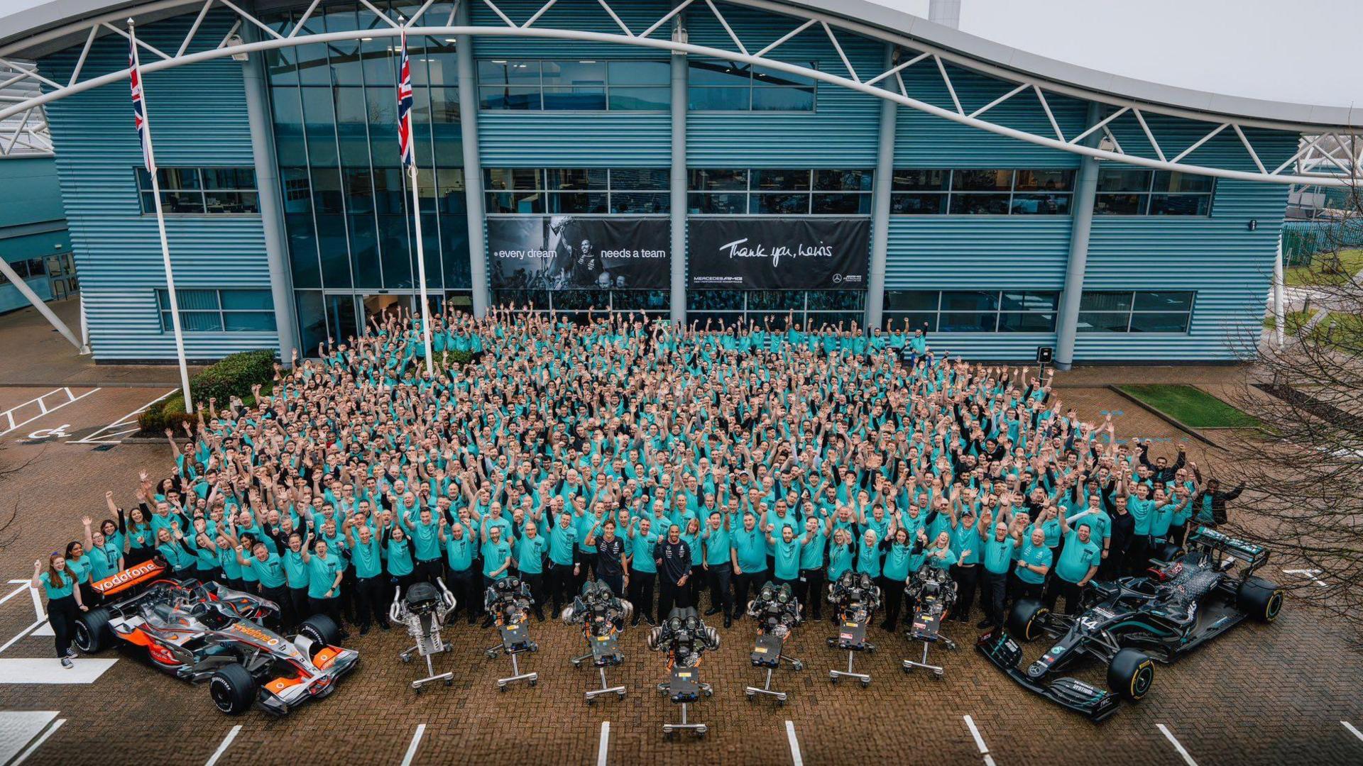 Hundreds of staff pose outside Mercedes' factory in Brixworth alongside Lewis Hamilton, George Russell, two of Hamilton's winning cars and seven F1 car engines - one for each of Hamilton's titles with the team.