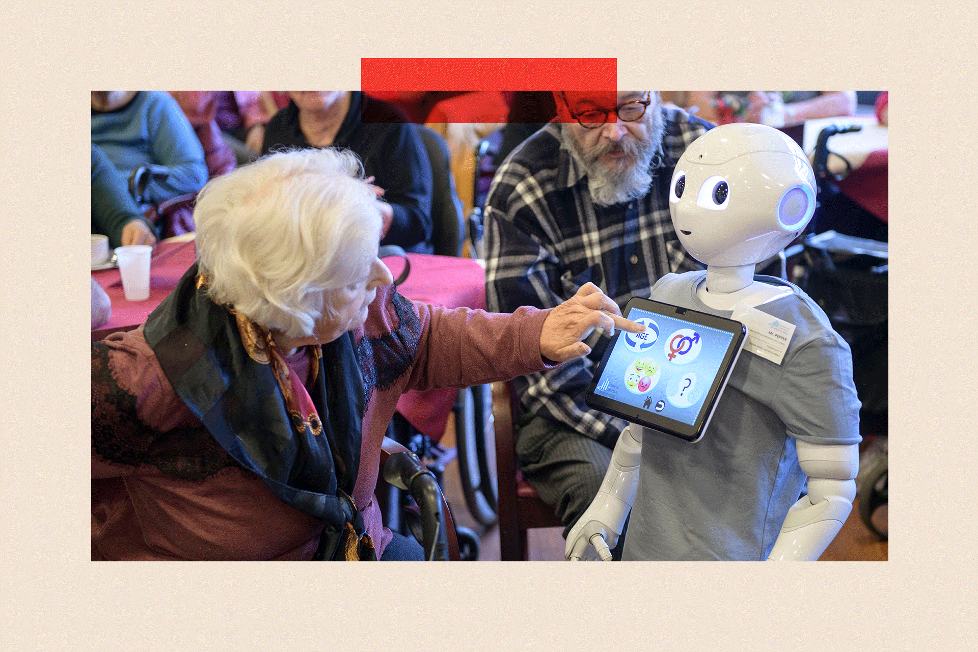 An elderly woman looks to a robot and touches the screen on its front