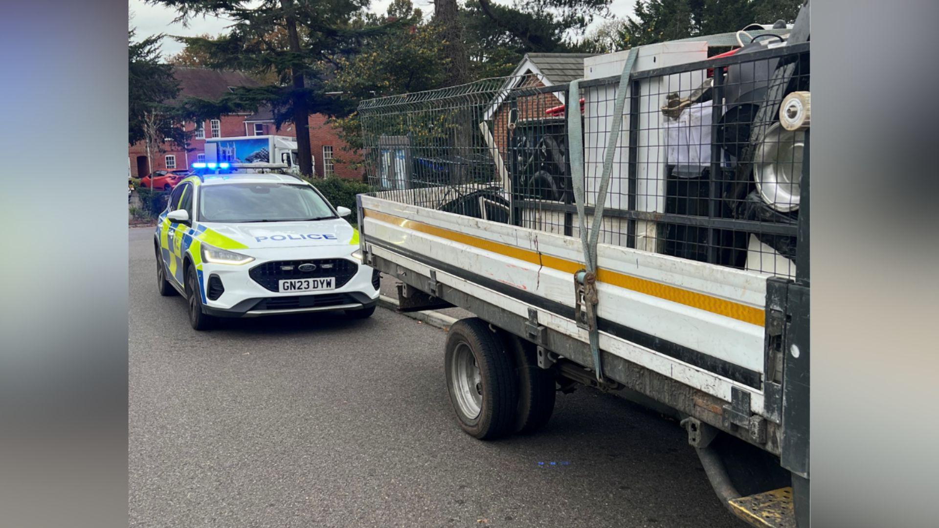 A police car parked behind a lorry.