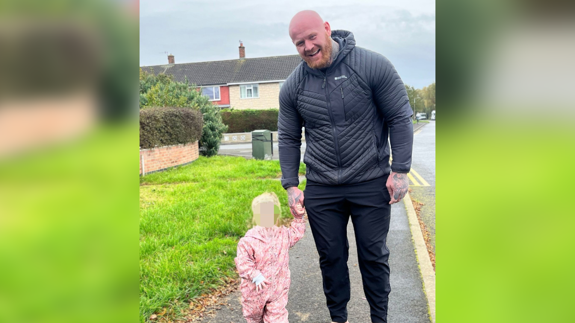 A handout of Lenny Scott walking outside with his daughter, whose face has been obscured. He is smiling and wearing a coat, and tracksuit bottoms. She is wearing a full body rain-suit.