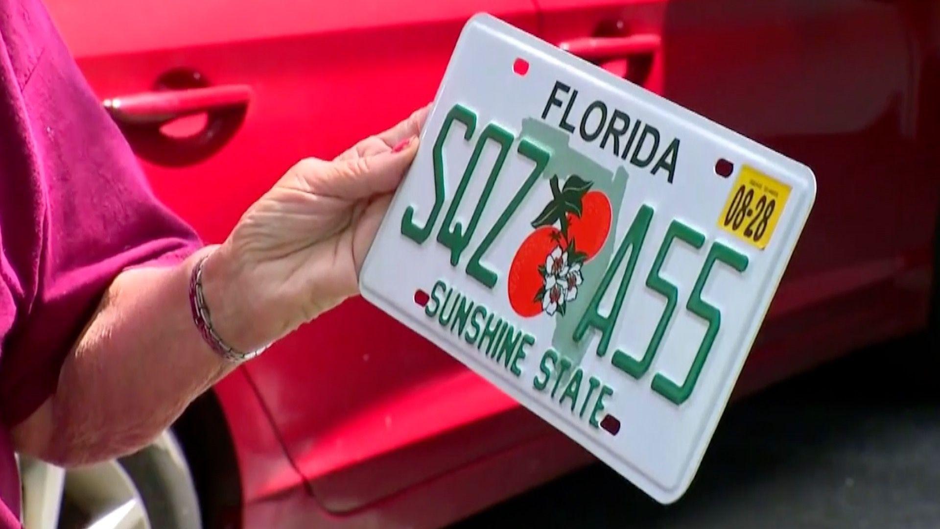 The woman holding the license plate that says SQZ A55