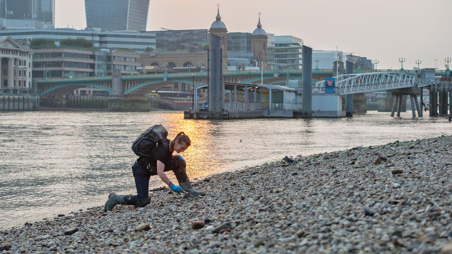 a mudlarker digging by the Thames