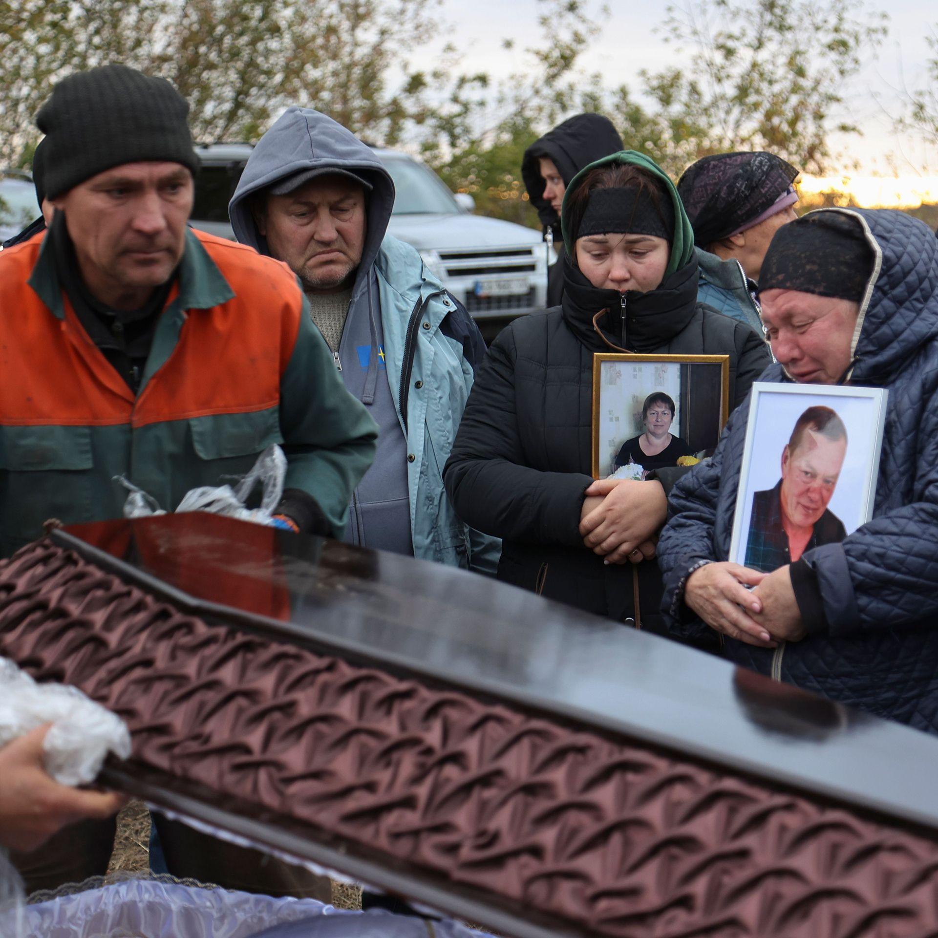 People attend the funeral ceremony of fellow villagers killled in a Russian strike, at the cemetery of Hroza, Kupiansk district, Kharkiv region, Ukraine, 09 October 2023.