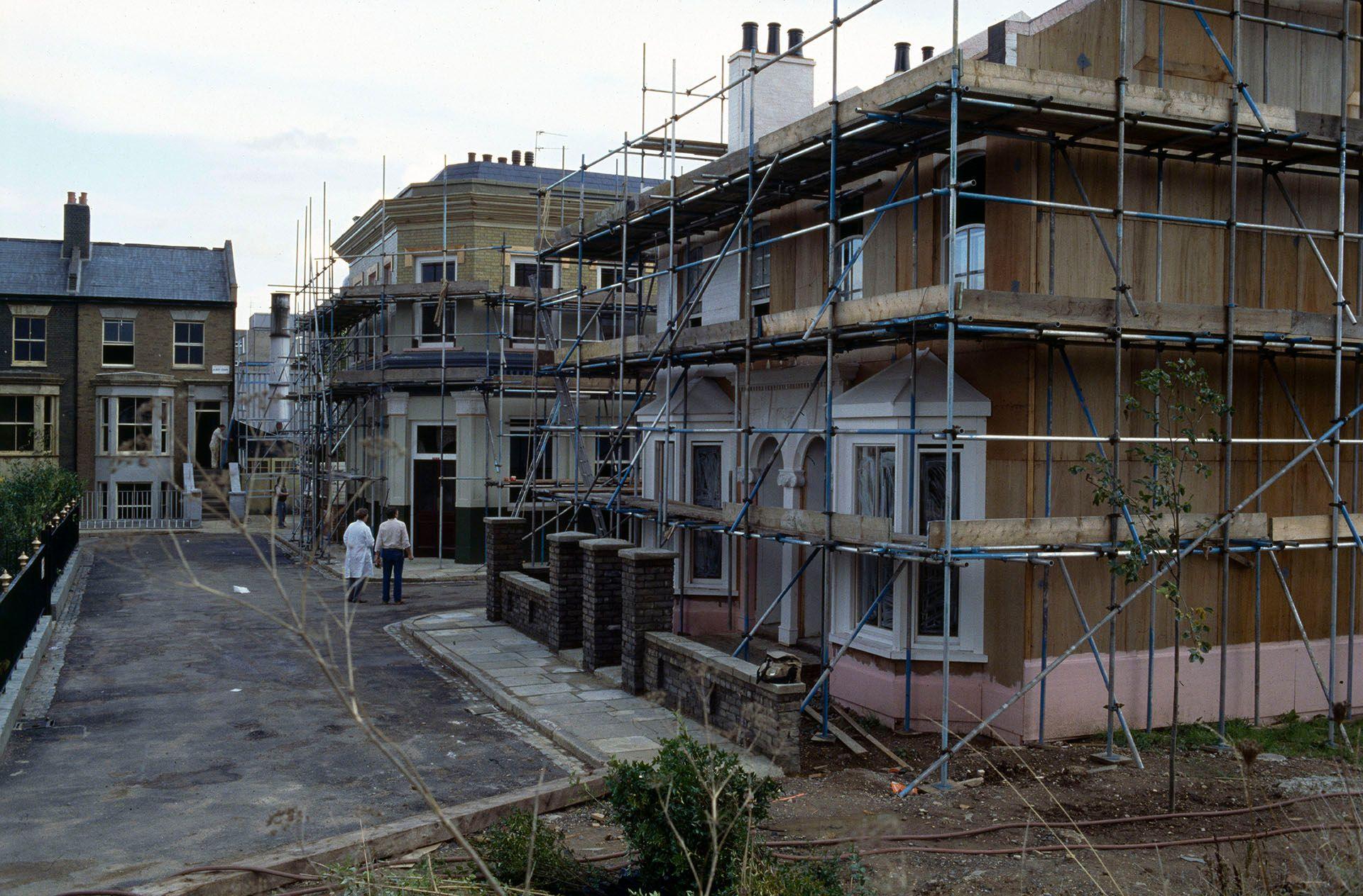 a street of buildings on the albert square set covered in scaffolding