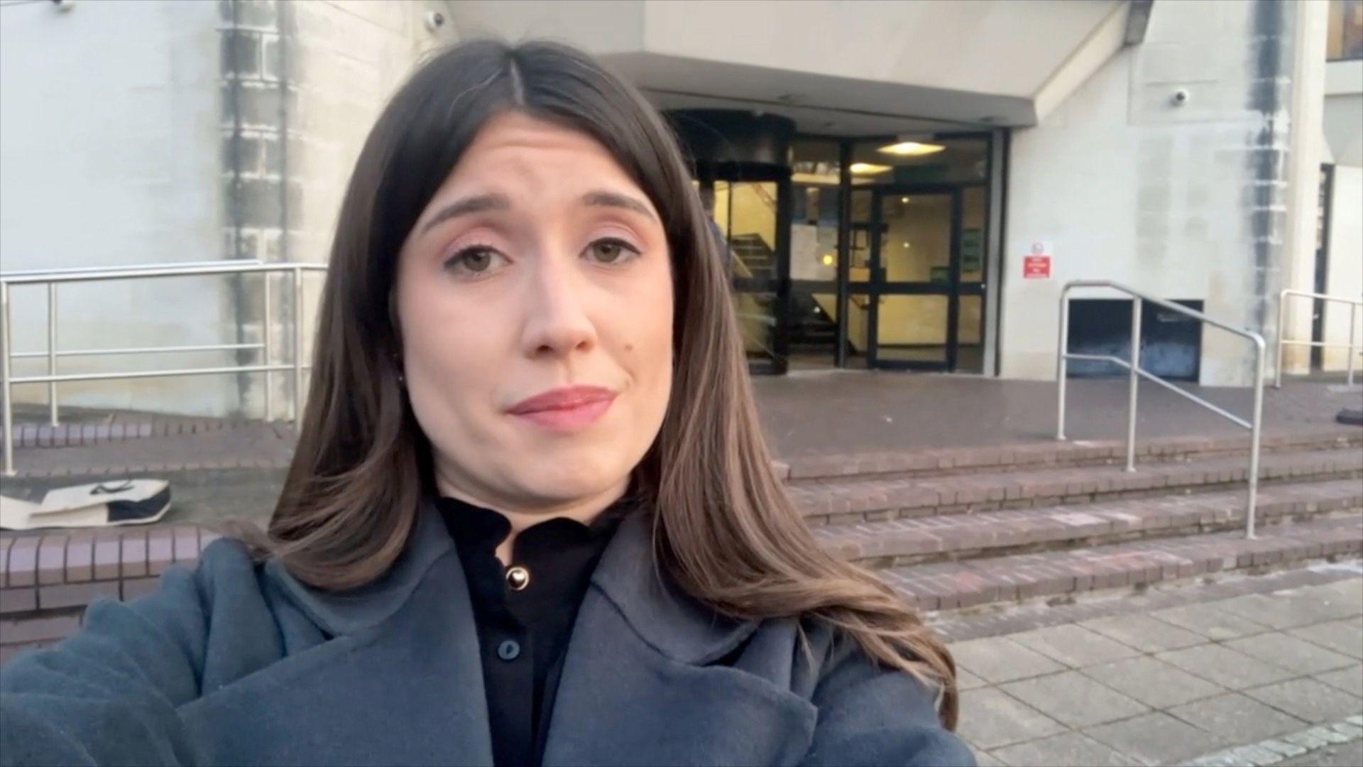 A woman with dark hair outside court