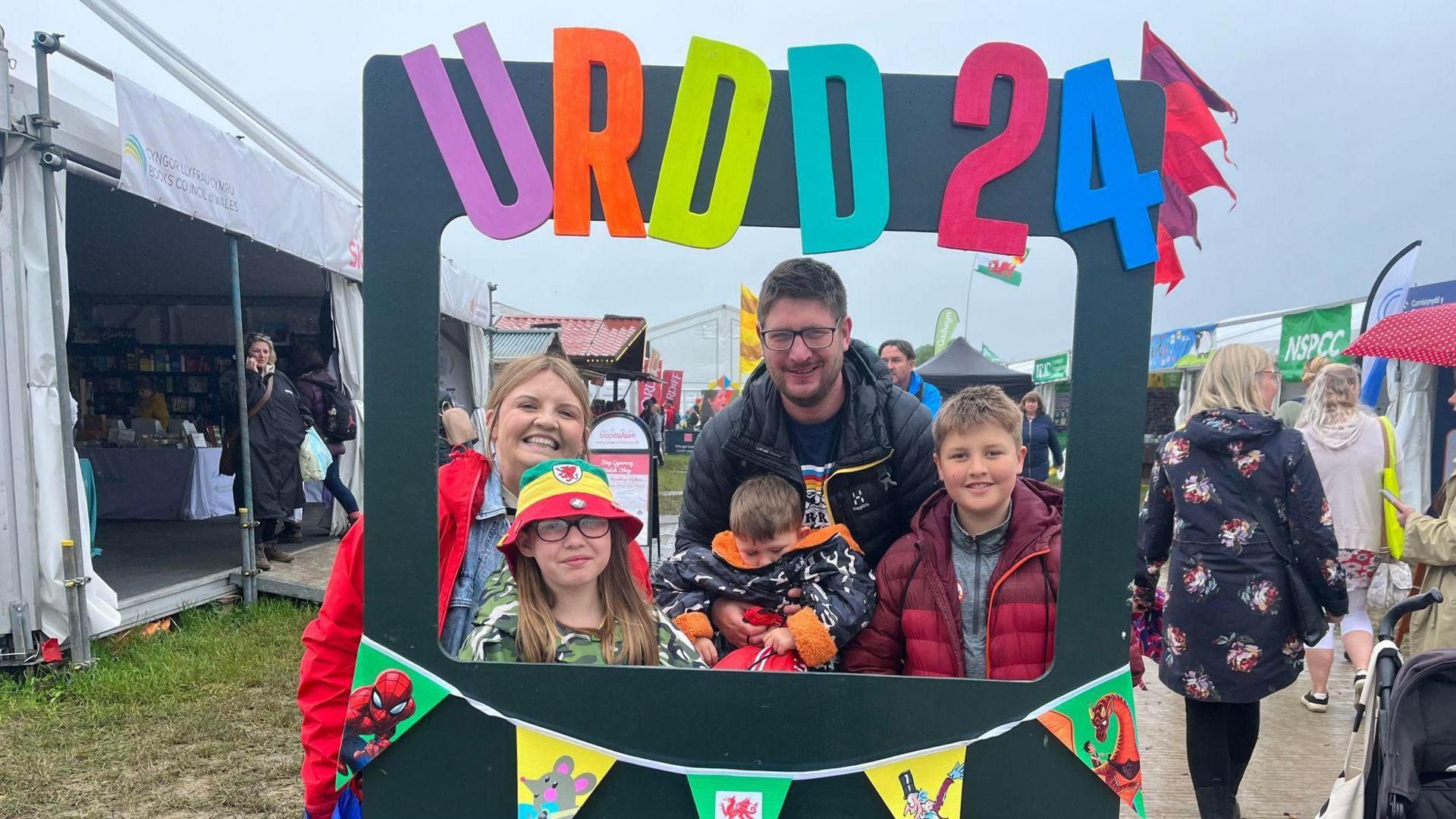 Sioned and James wander round the muddy Maes with children Efan, 10, Erin, eight, and Noa, four
