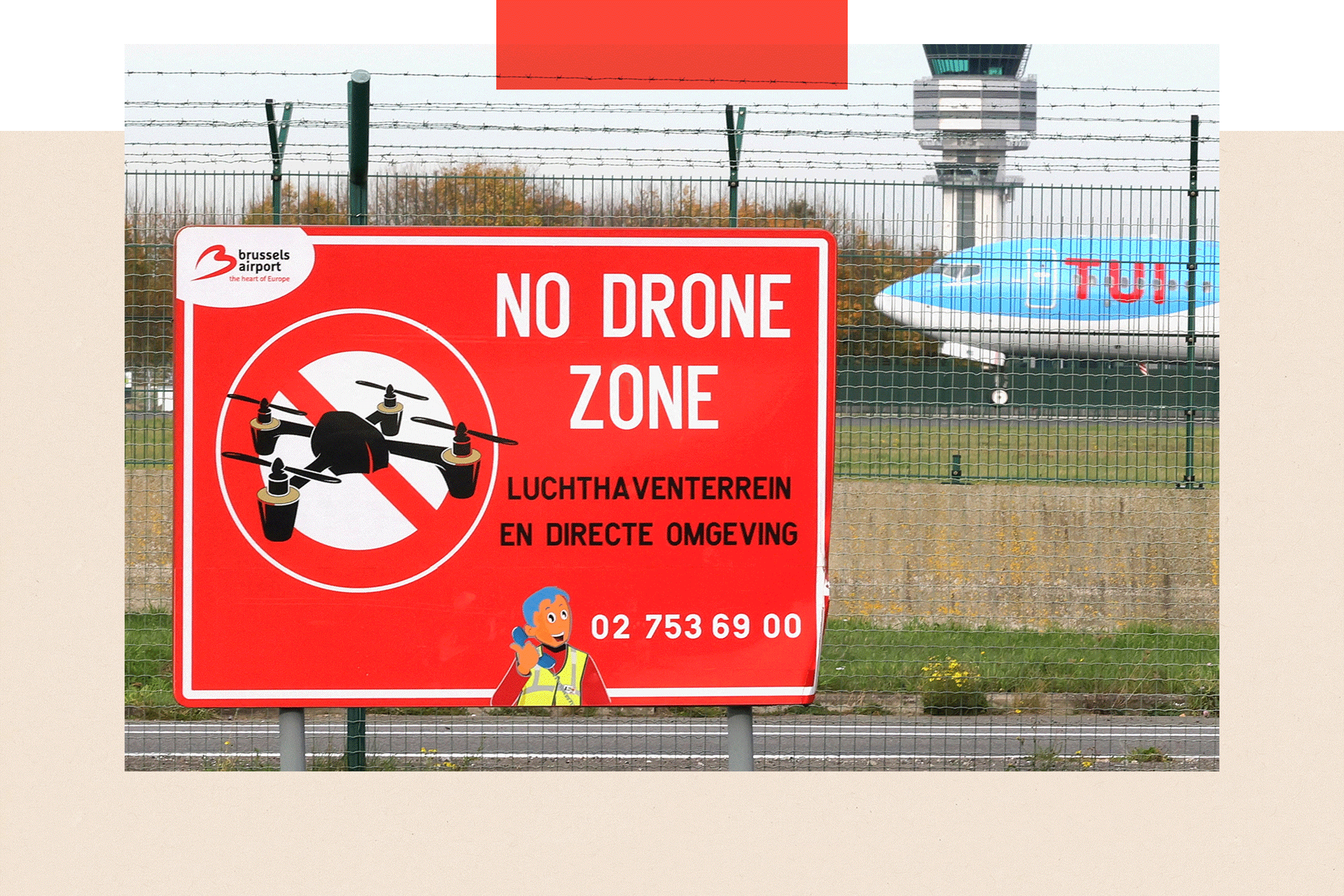 An aircraft lands on the tarmac near a "No Drone Zone" placard 
