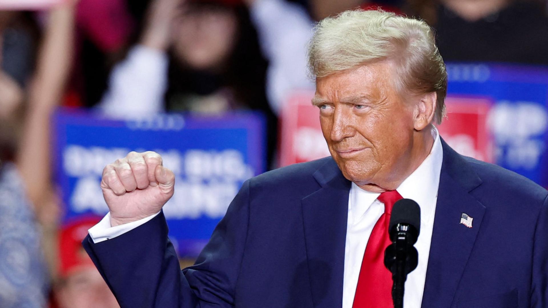 Donald Trump pumps his fist while speaking to supporters