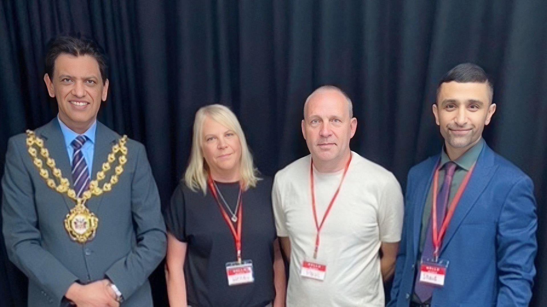 Zahid Chauhan, wearing a grey suit and gold mayoral chains, stands on the left of Wendy and Paul, with councillor Shaid Mushtaq, wearing a blue suit, on the right. 