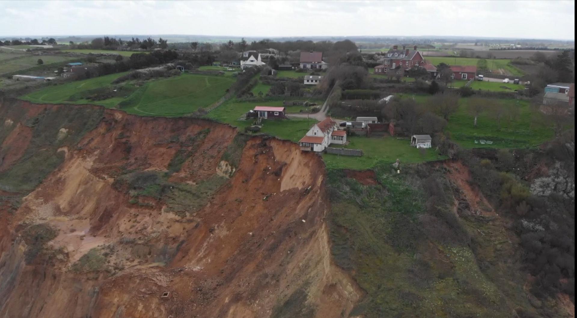 A drone image of the farmhouse partially hanging over the cliff edge