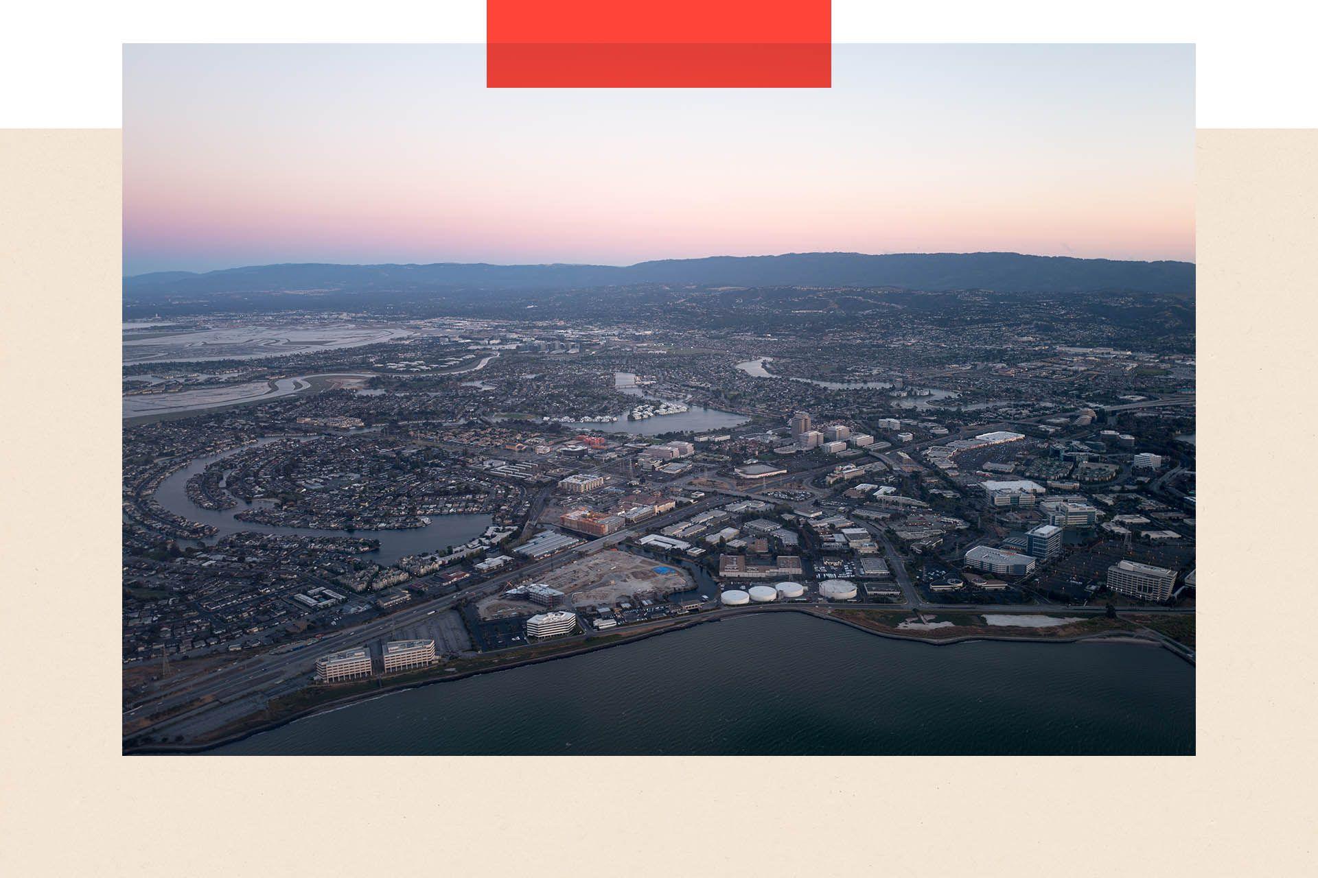 Aerial view of Silicon Valley at dusk, with a portion of the San Mateo/Hayward Bridge visible, as well as Foster City, including the California headquarters of Gilead Sciences, Visa, and Conversica, California