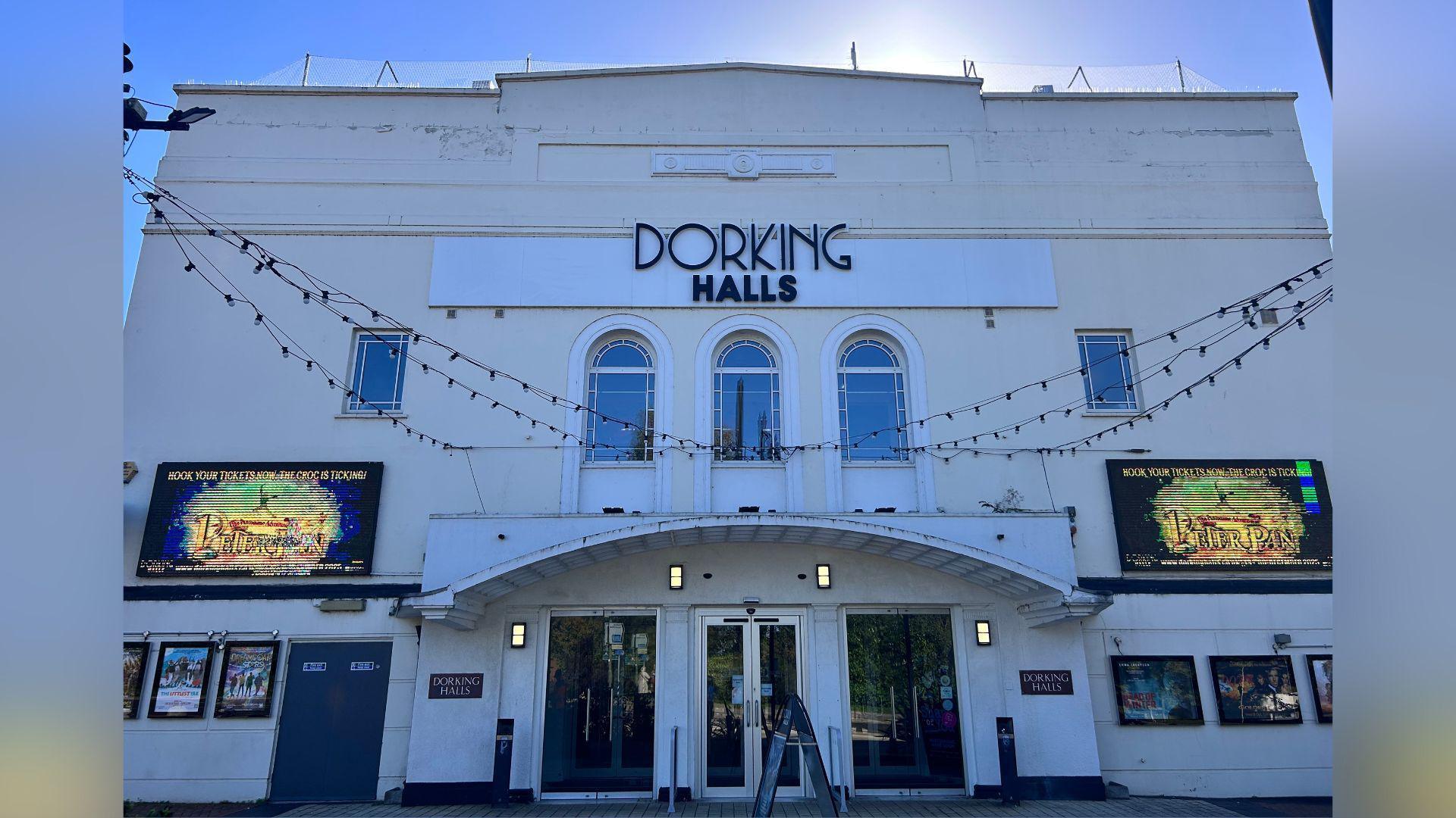 The outside of a large white theatre building. 