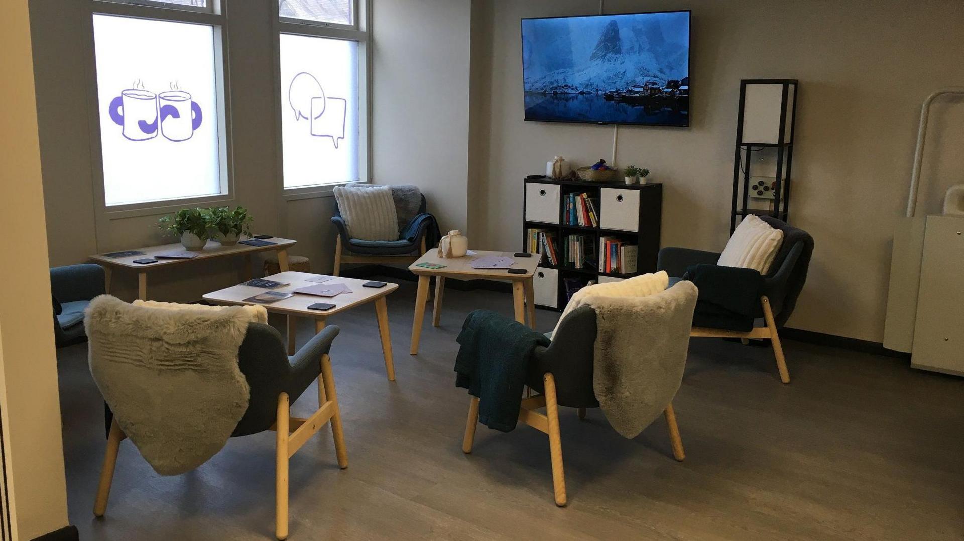 Reception area in The Bothy featuring chairs, blankets, cushions and a flat screen television