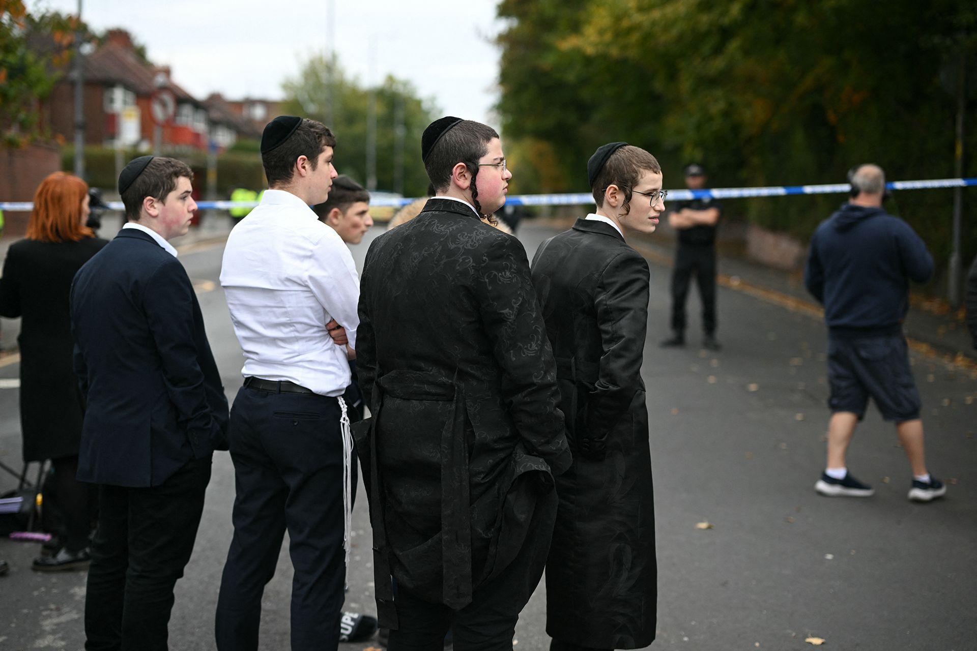 Members of the local community stand by a police cordon near to Heaton Park Hebrew Congregation synagogue in Crumpsall, north Manchester, on October 2, 2025