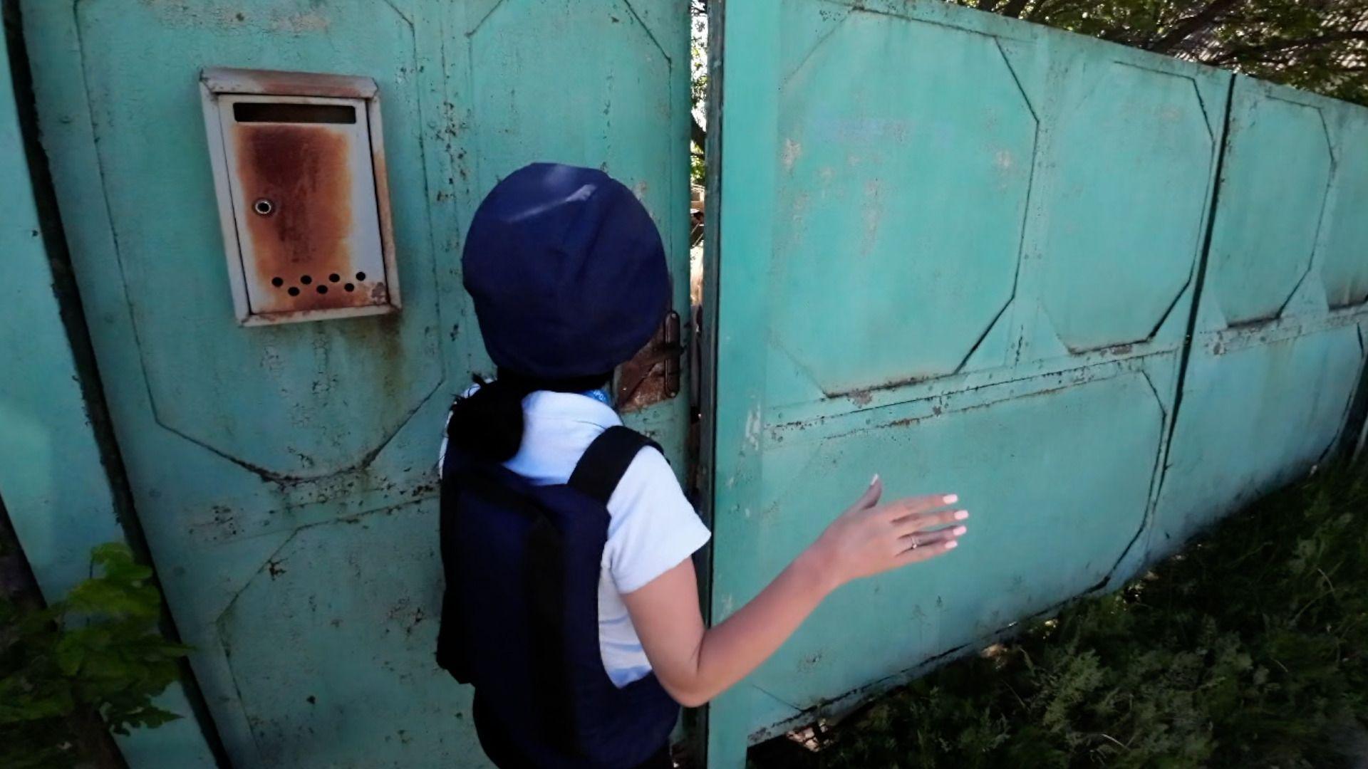 Vika Pisna stands outside a gate 