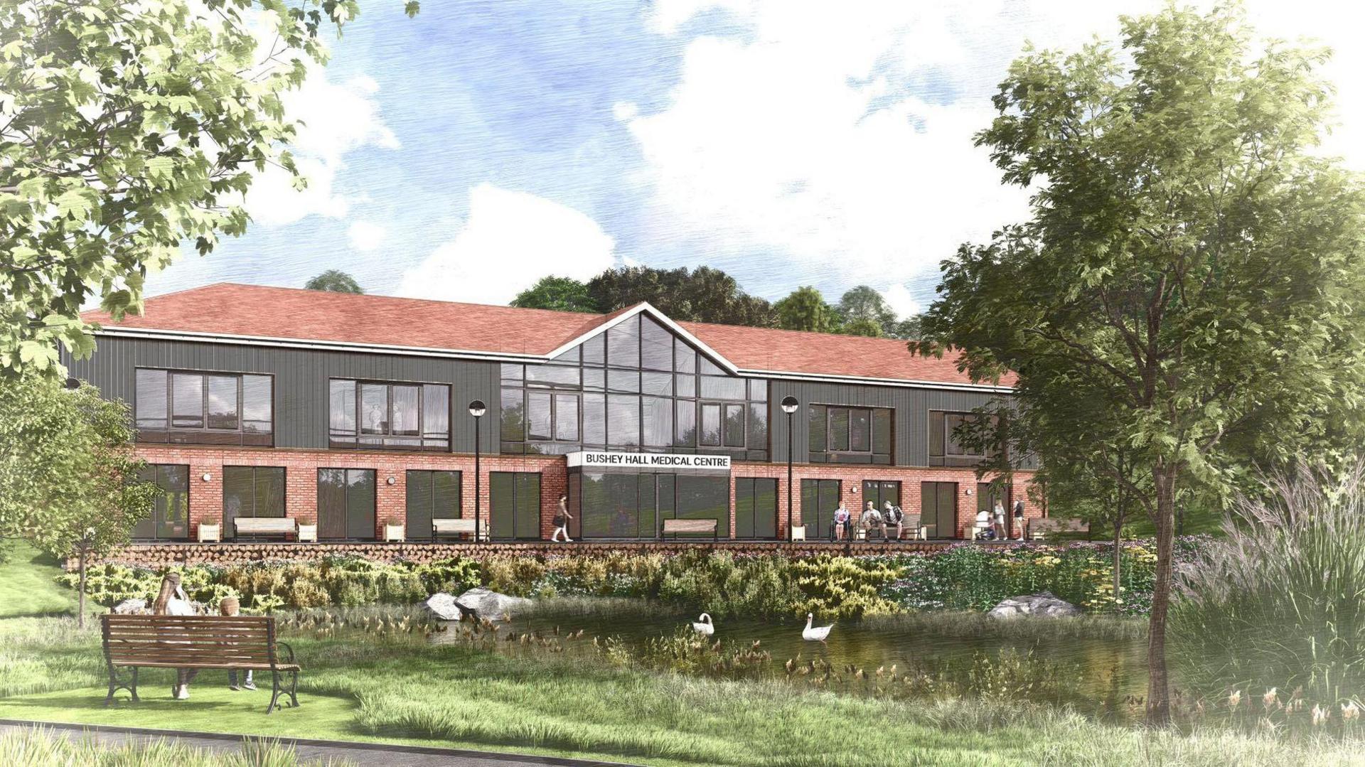 A computer-generated image of a building which has a sign saying "Bushey Hall Medical Centre" at the entrance. It is a two-storey building in front of a pond with swans on it.