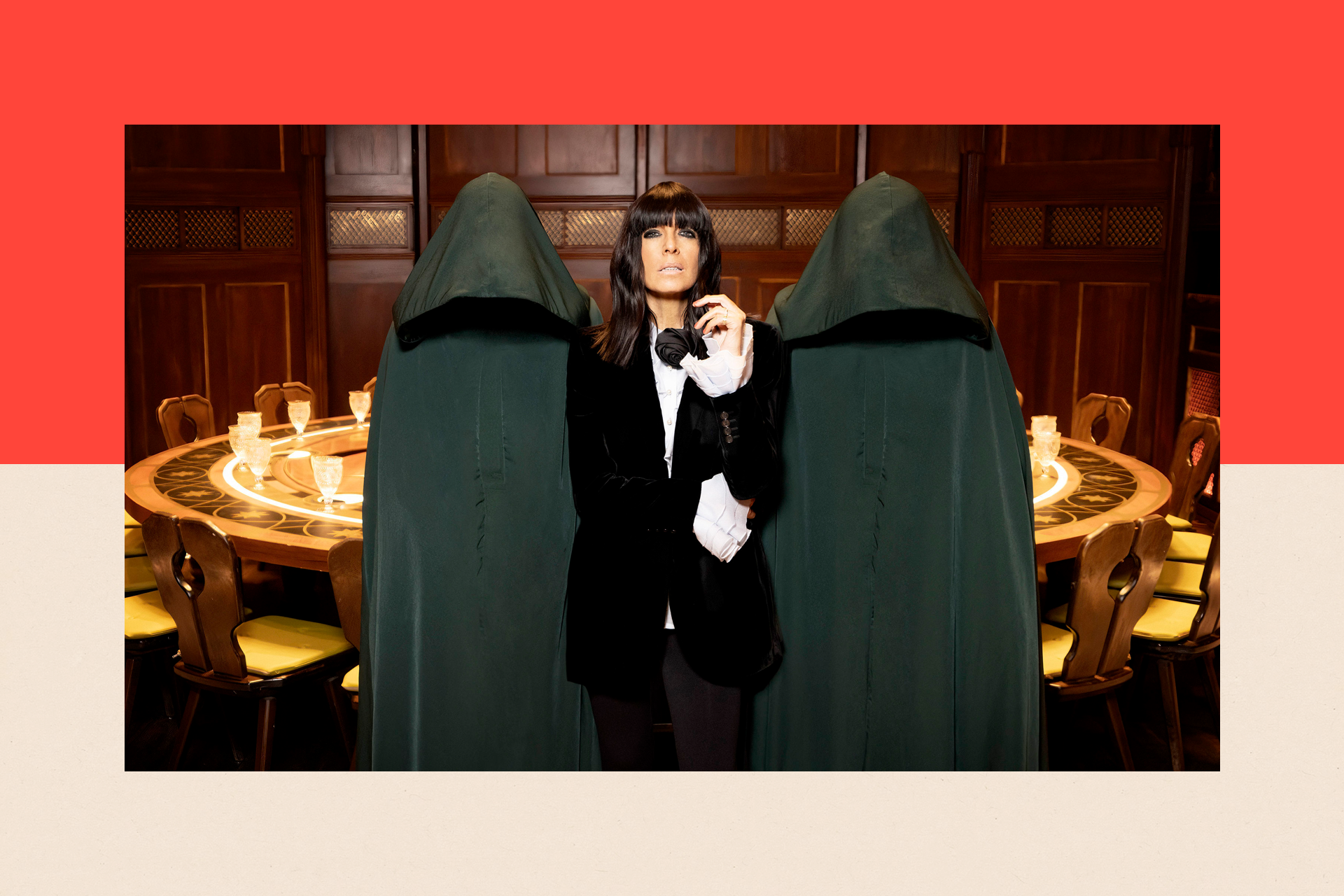 Presenter Claudia Winkleman stands next to two hooded figures