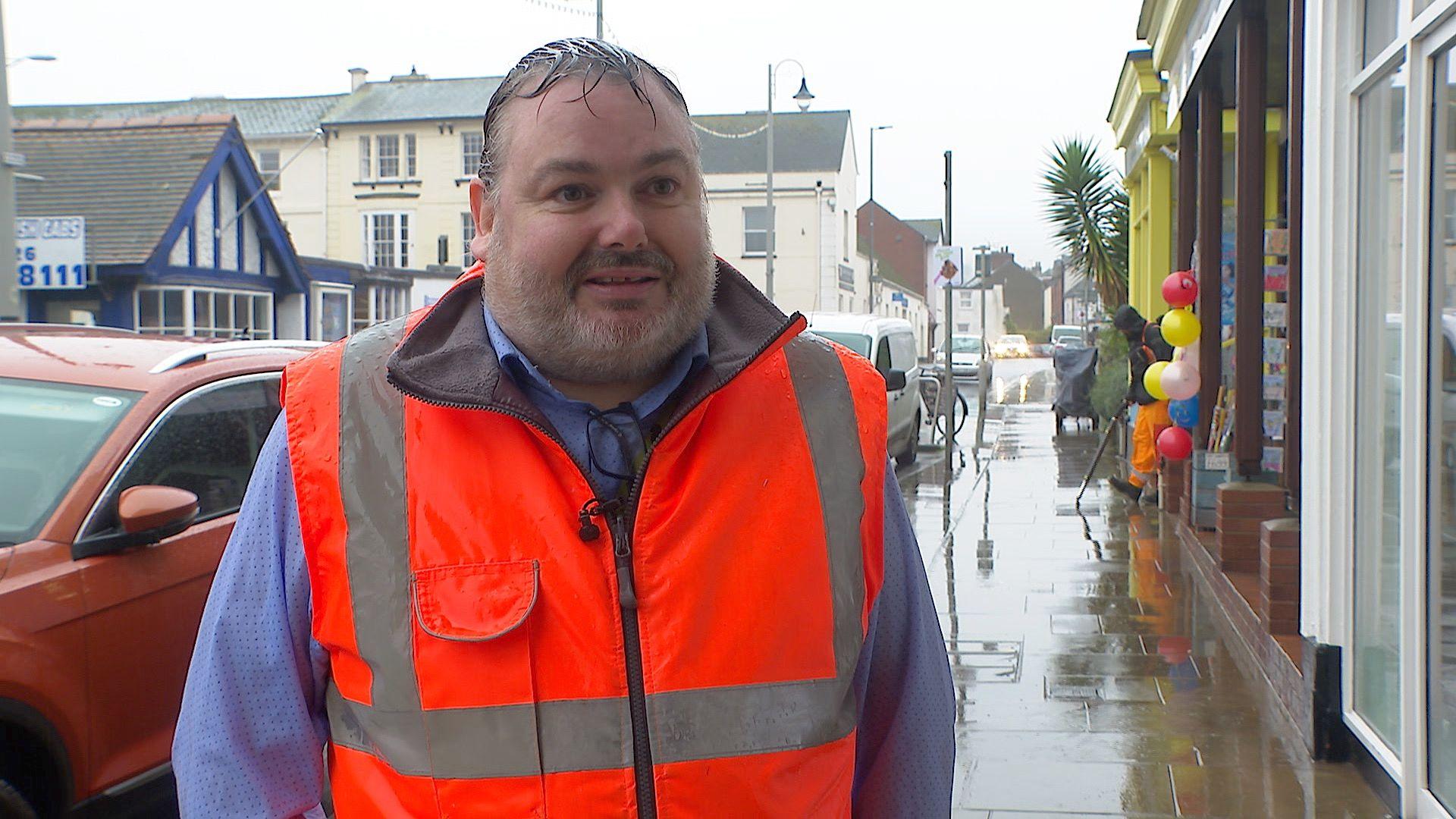 Mark Pepper, Waste Operations Manager for Teignbridge Council in a high-viz jacket on a wet day in a Devon town.