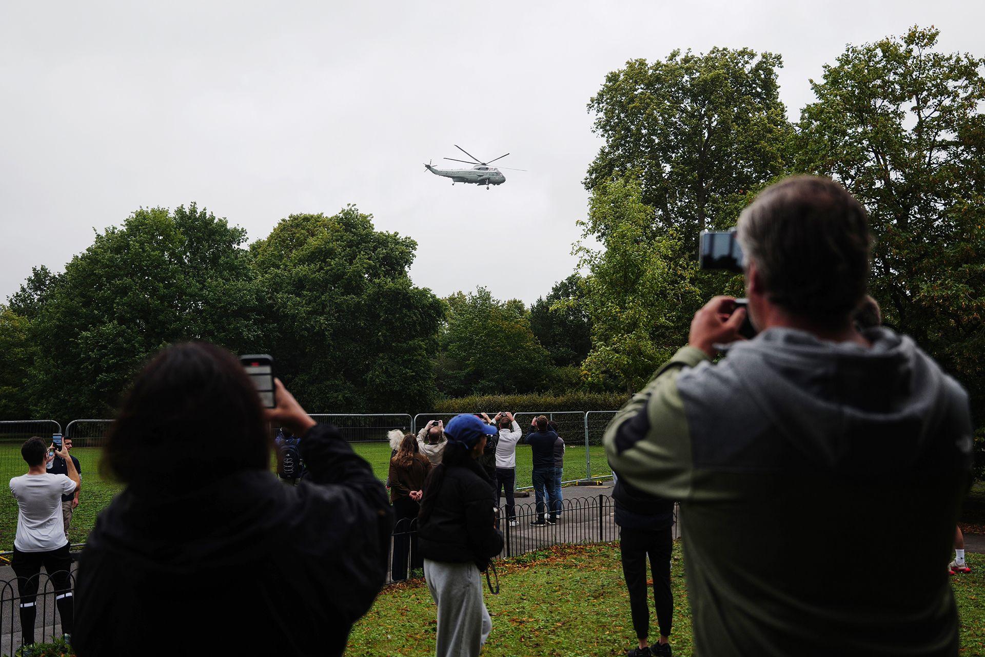 Bystanders take photographs as the Marine One helicopter departs from Winfield House, the US Ambassador's residence, in London