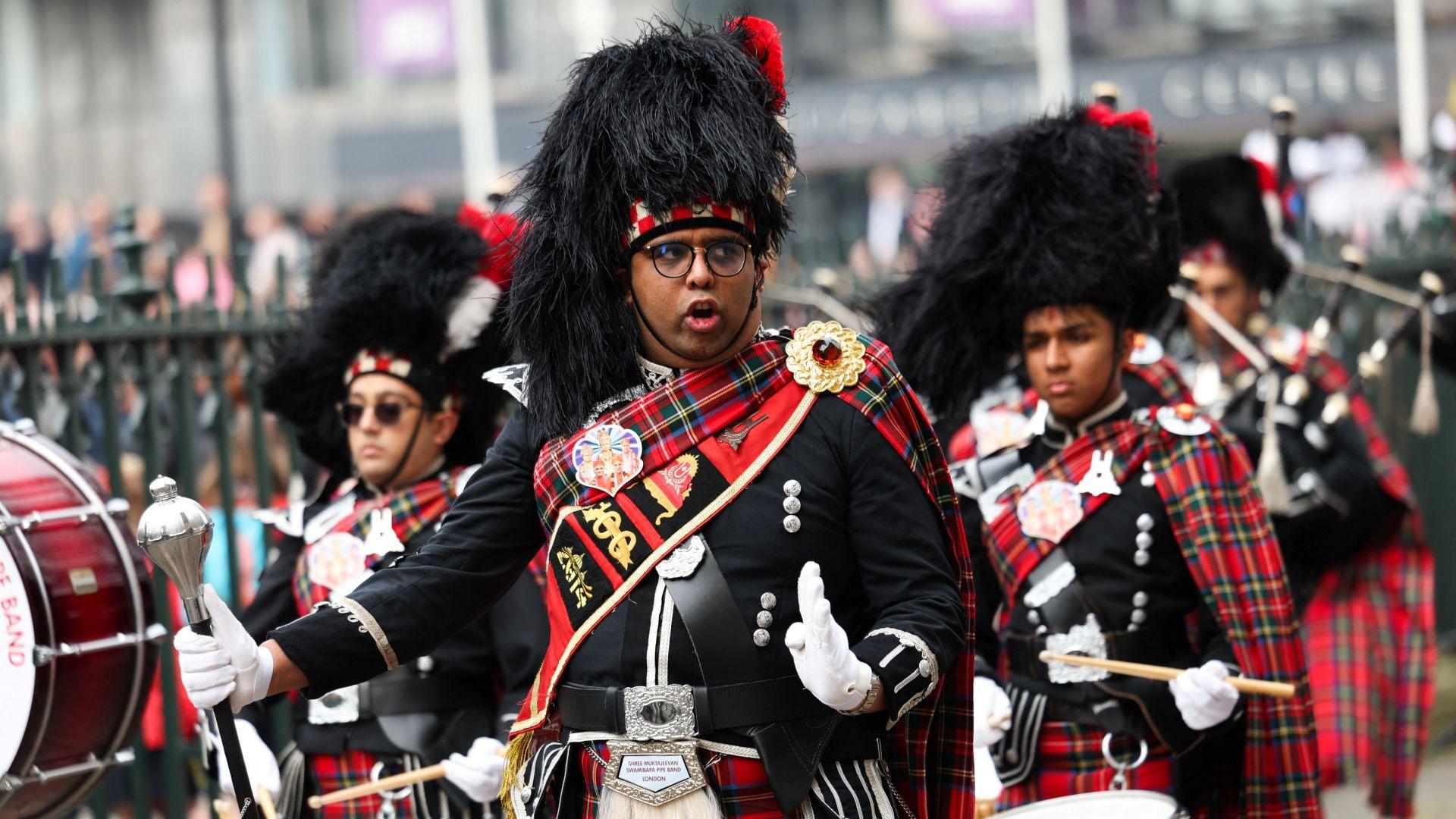 Members of Shree Muktajeevan Swamibapa Pipe Band perform while wearing tartan kilts.