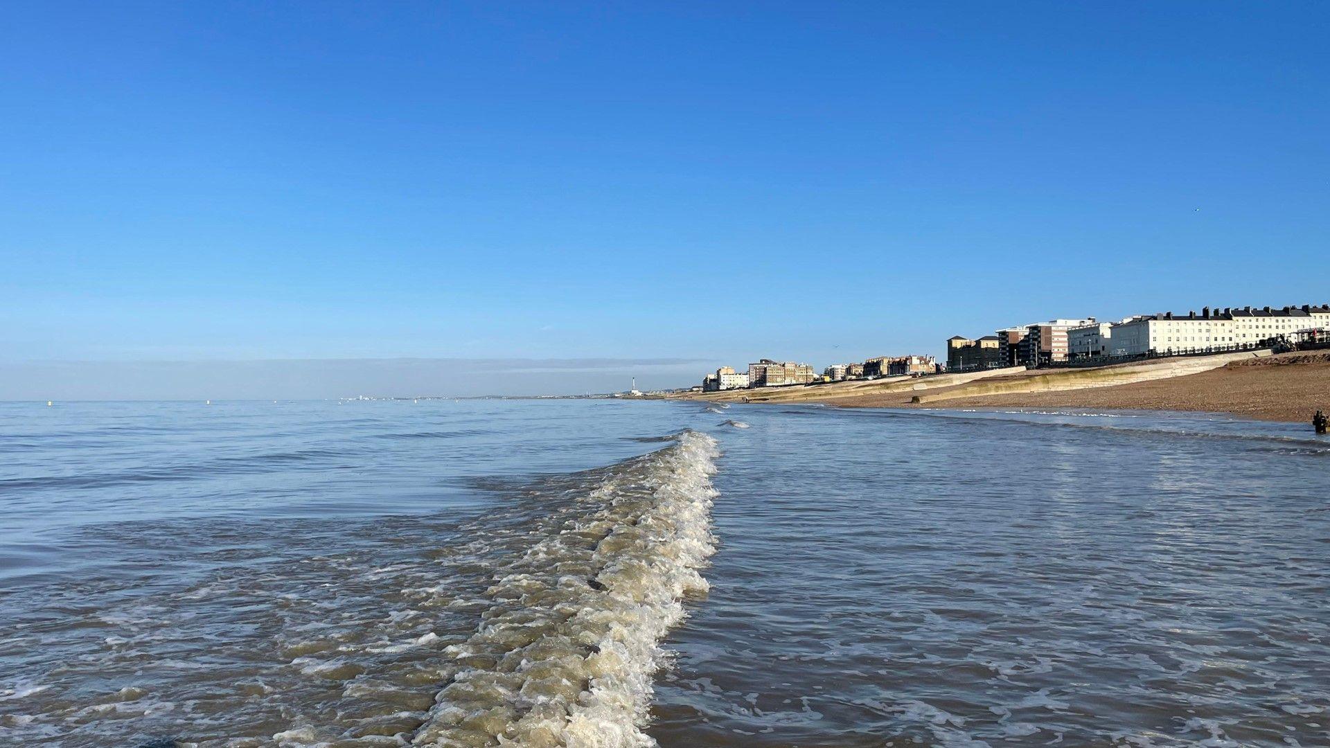 Blue, largely cloudless sky over sea and coast at Brighton and Hove