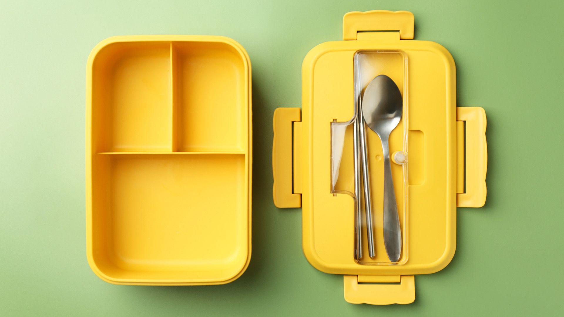 Yellow lunchbox with three compartments and spoon and chopsticks